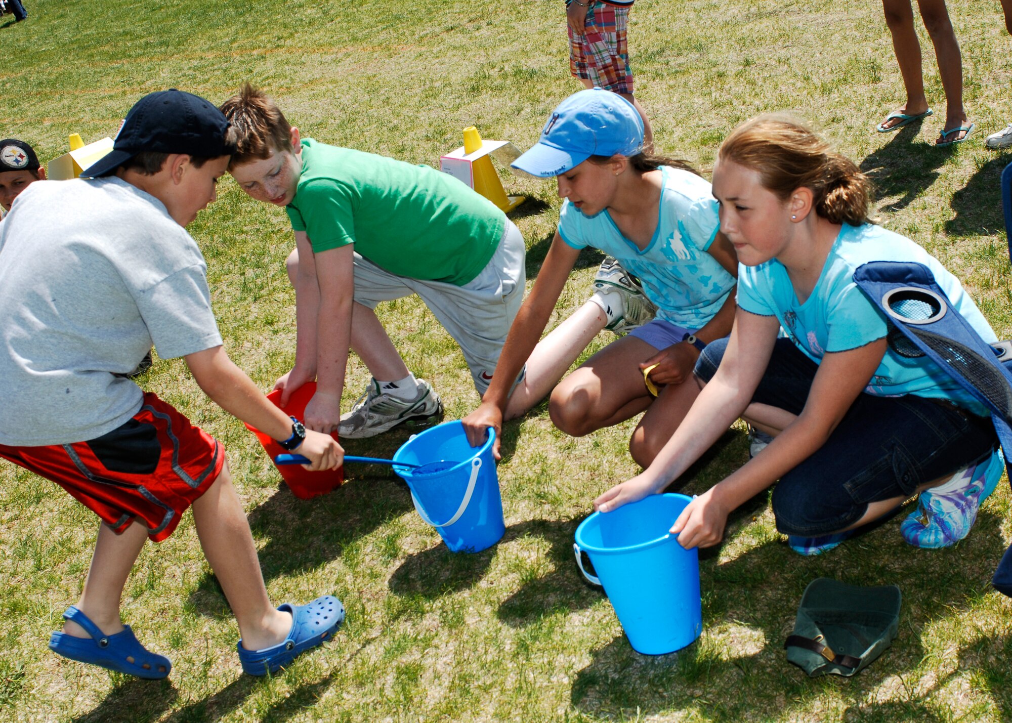 A student from Michael Anderson Elementary School pours objects into his respective bucket during a kid’s day competition June 1. (U.S. Air Force photo / Senior Airman Joshua K. Chapman)