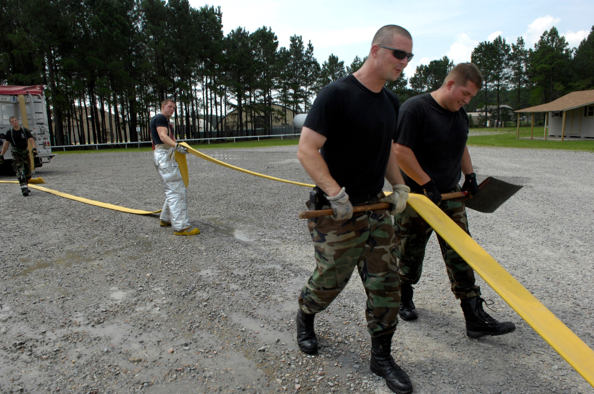SHAW AIR FORCE BASE, S.C. -- Members of the 20th Civil Engineer Squadron fire protection flight flatten a fire hose after neutralizing a live fire during Team Shaw's operational readiness inspection, June 15. The ORI will evaluate Shaw's ability to survive and operate in combat conditions. (U.S. Air Force photo/Senior Airman Kathrine McDowell)