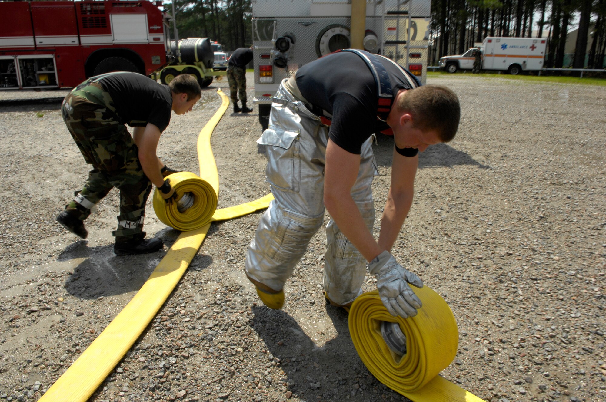 SHAW AIR FORCE BASE, S.C. -- Members of the 20th Civil Engineer Squadron fire protection flight roll up their fire hoses after neutralizing a live fire during Team Shaw's operational readiness inspection, June 15. The ORI will evaluate Shaw's ability to survive and operate in combat conditions. (U.S. Air Force photo/Senior Airman Kathrine McDowell)