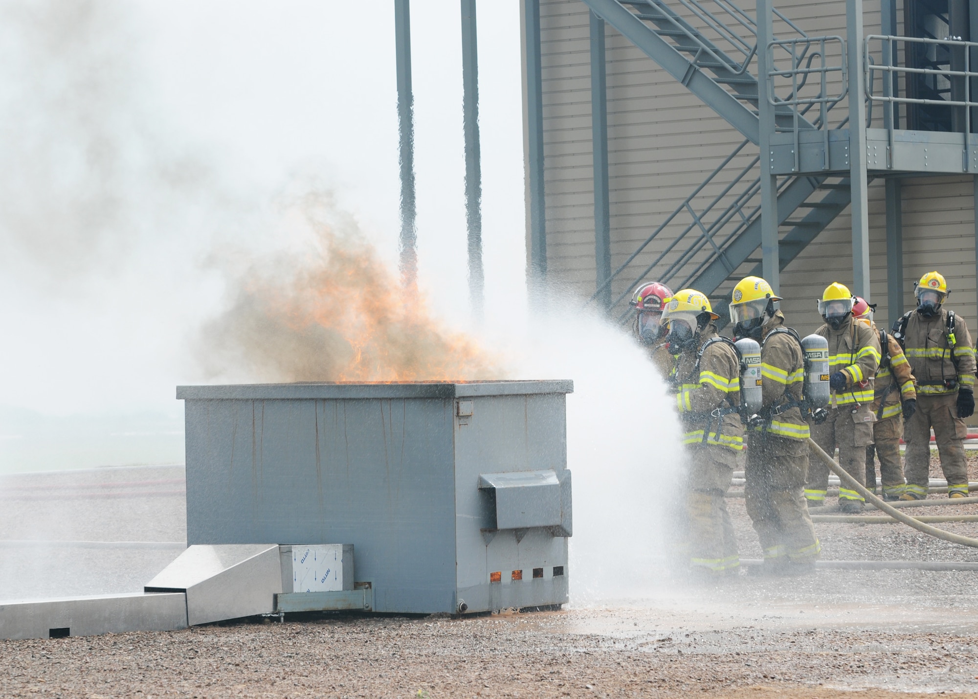 ALTUS AIR FORCE BASE, Okla. – A three-person team extinguishes a dumpster fire during firefighter certification June 14.  This was part of training held at Altus AFB where civilian firefighters joined with Altus AFB firefighters to gain certification. The Altus AFB certification facility is the only one of its kind in southwestern Oklahoma.  (U.S. Air Force photo/Senior Airman Jennifer L. Flores)

