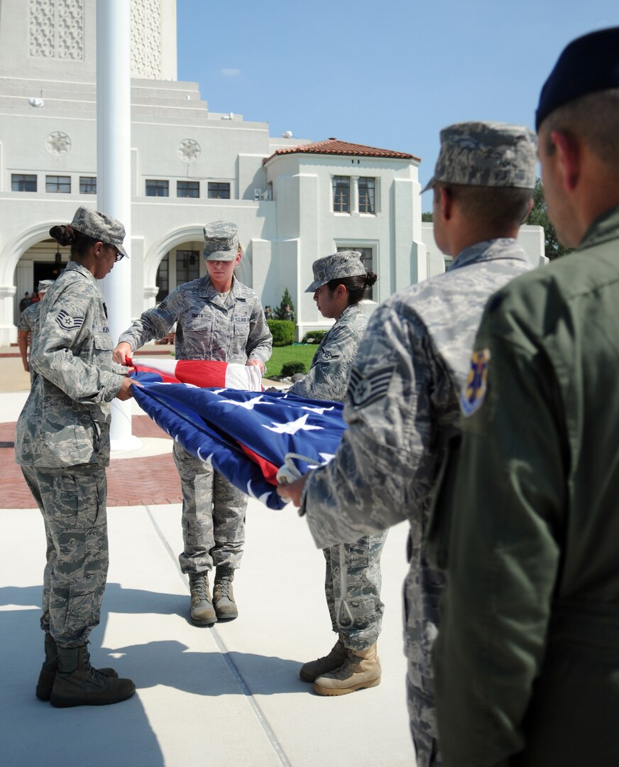 Airmen from the 12th Medical Group take down and fold the U.S. flag during the quarterly retreat ceremony June 12. Medics joined fellow 12th Flying Training Wing Airmen in paying respects to the nation's "Stars and Stripes." (U.S. Air Force photo by Don Lindsey)