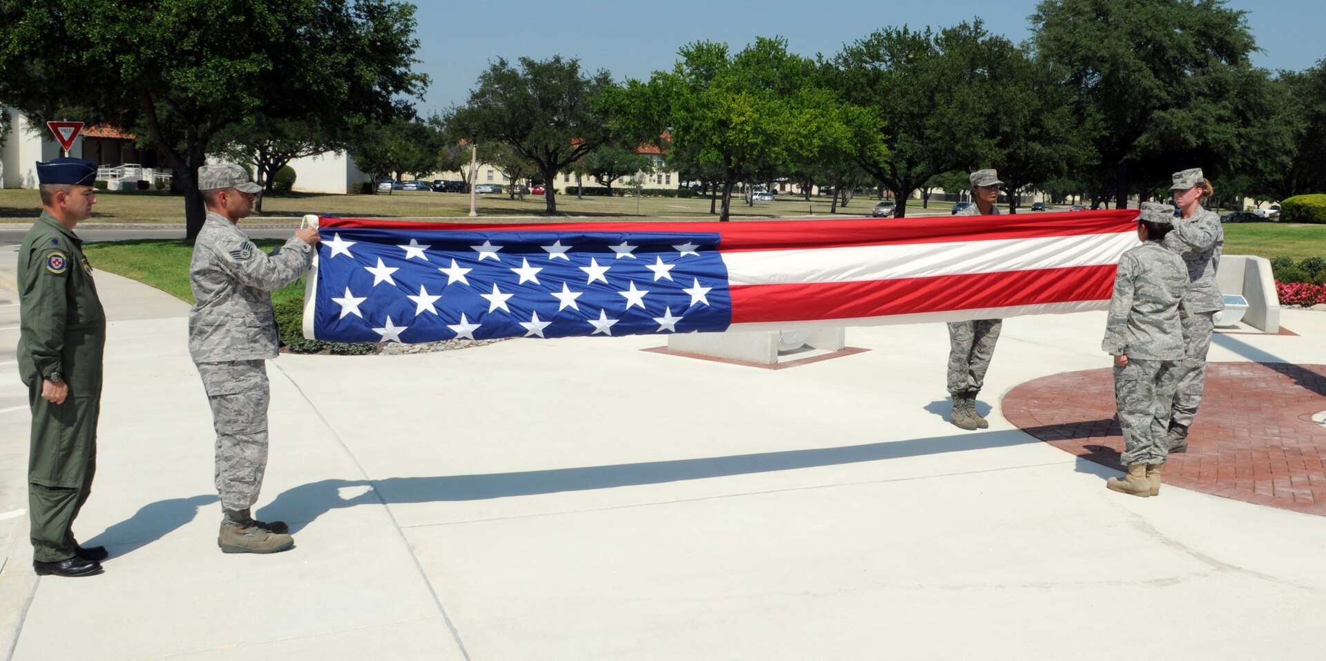 Airmen from the 12th Medical Group take down and fold the U.S. flag during the quarterly retreat ceremony June 12. Medics joined fellow 12th Flying Training Wing Airmen in paying respects to the nation's "Stars and Stripes." (U.S. Air Force photo by Don Lindsey)