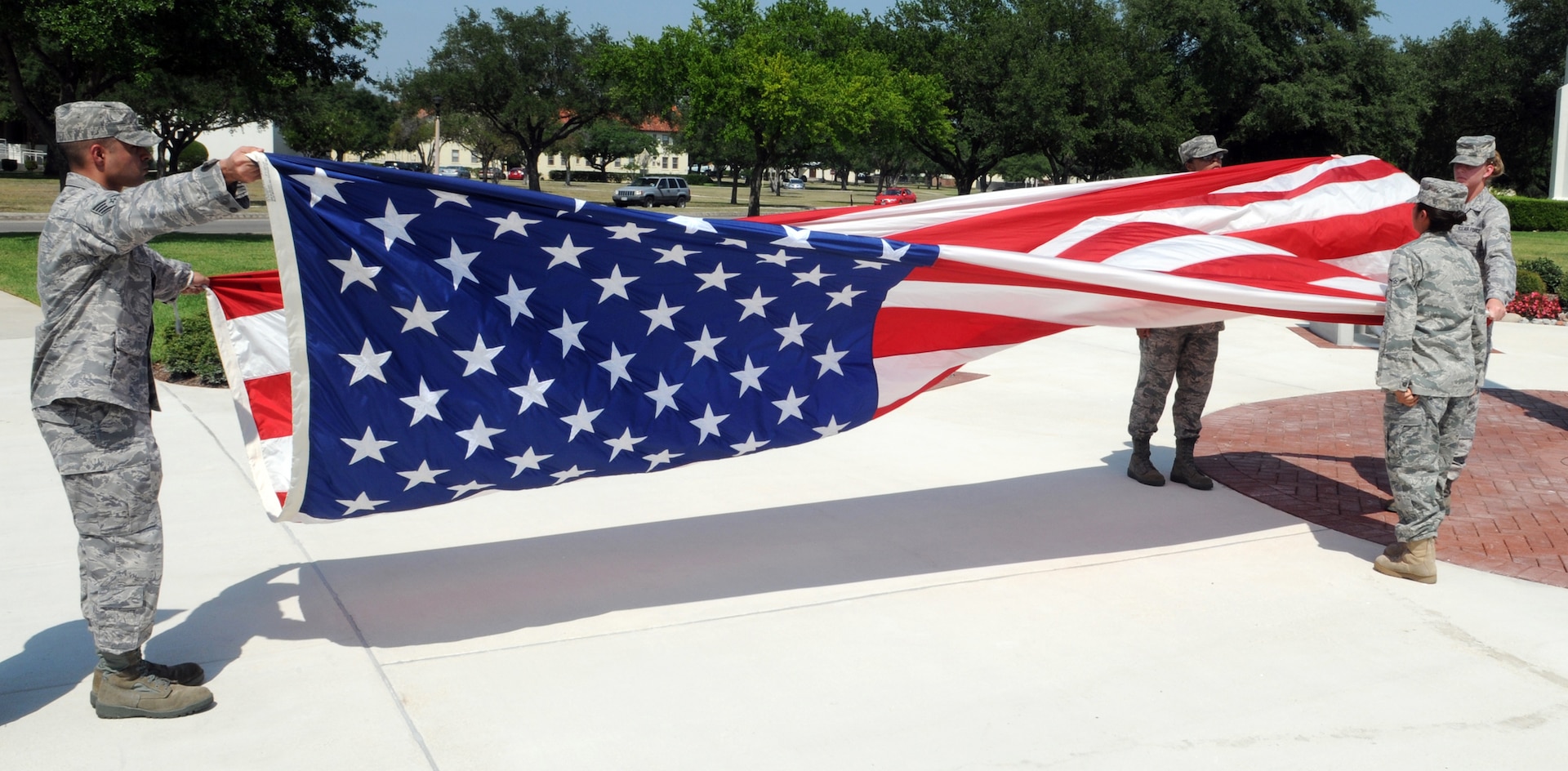 Airmen from the 12th Medical Group take down and fold the U.S. flag during the quarterly retreat ceremony June 12. Medics joined fellow 12th Flying Training Wing Airmen in paying respects to the nation's "Stars and Stripes." (U.S. Air Force photo by Don Lindsey)
