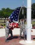 Airmen from the 12th Medical Group take down and fold the U.S. flag during the quarterly retreat ceremony June 12. Medics joined fellow 12th Flying Training Wing Airmen in paying respects to the nation's "Stars and Stripes." (U.S. Air Force photo by Don Lindsey)