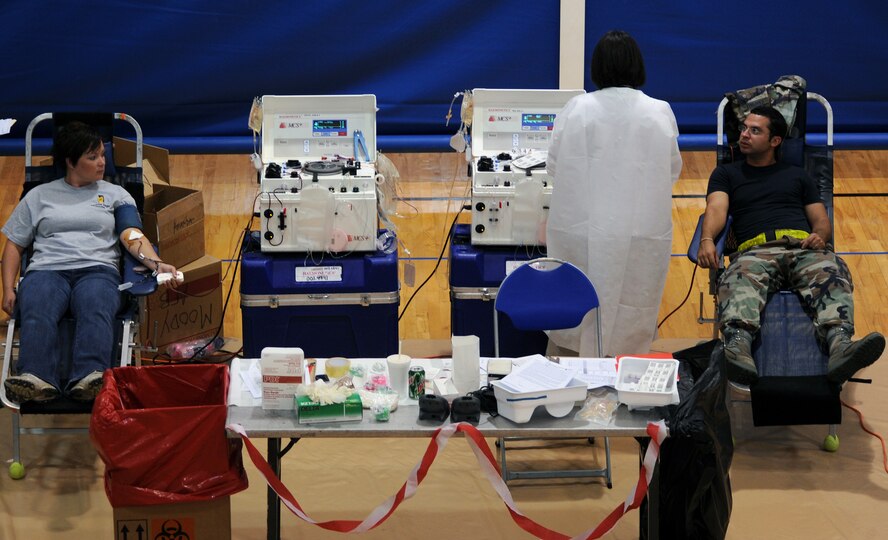 MOODY AIR FORCE BASE, Ga. -- Staff Sgt. Regina Cooper, 23rd Civil Engineer Squadron dorm manager, and Airman 1st Class James Campbell, 23rd Aircraft Maintenance Squadron crew chief, donate blood through a machine during the American Red Cross blood drive here June 12. The machine is used when people are donating more than a pint of blood. (U.S. Air Force photo by Airman 1st Class Joshua Green)
