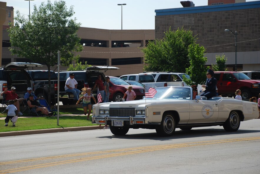 Col. Marti Rossi, 82nd Training Wing director of staff, throws candy June 13 in the 72nd Annual Oil Bowl Kickoff Parade. The parade kicked off the Maskat Shrine Oil Bowl Classic, a football game between Texas and Oklahoma high school football all-stars that raises money for the North Texas Rehabilitation Center of Wichita Falls and Oklahoma Society for Crippled Children among others. (U.S. Air Force photo/ Airman 1st Class Matthew Varga)