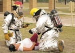 Firefighters from the 37th Civil Engineer Squadron assess a simulated injury during a major accident response exercise June 8. The training exercise tested the 37th Training Wing and the 59th Medical Wing on their ability to respond to a major incident. (U.S. Air Force photo/Robbin Cresswell)