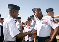 6/5/2009 - Chief Master Sgt. Juan Lewis (right), 37th Training Wing command chief, and Senior Airman Tara Gouveia (center), 37th Aerospace Medicine Squadron, congratulate an Airman who graduated from basic military training June 5. (U.S. Air Force photo/Robbin Cresswell)