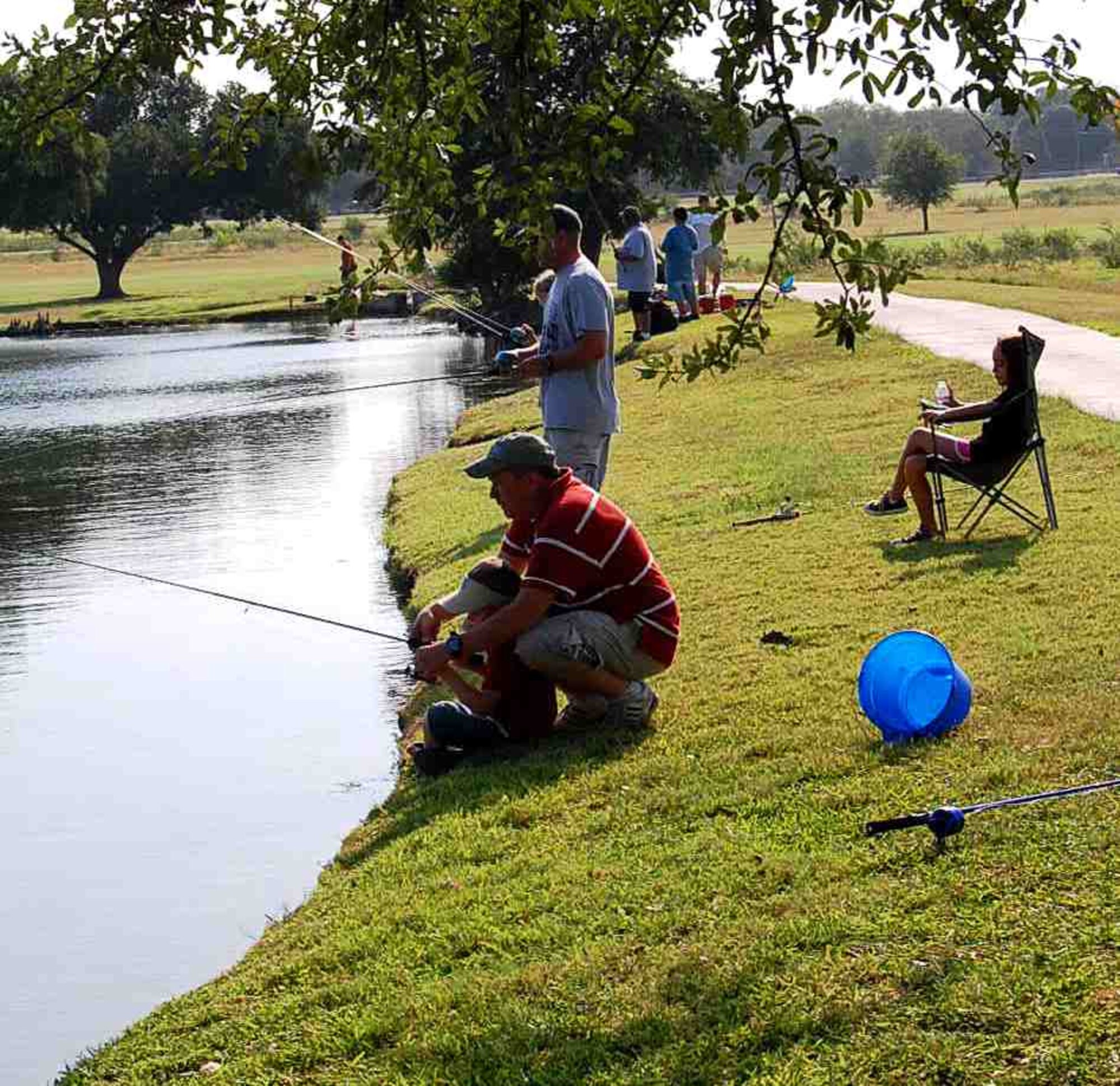 LAUGHLIN AIR FORCE BASE, Texas – Tech. Sgt. Thomas Cooper, 47th Security Forces Squadron, helps his son, Austin, fish during the Annual Fishing Day Derby for Laughlin parents and their children here June 12.  Kids spent the day fishing with their parents to compete for the largest fish catch of the day. (U.S. Air Force photo by Gabriela Vargas)