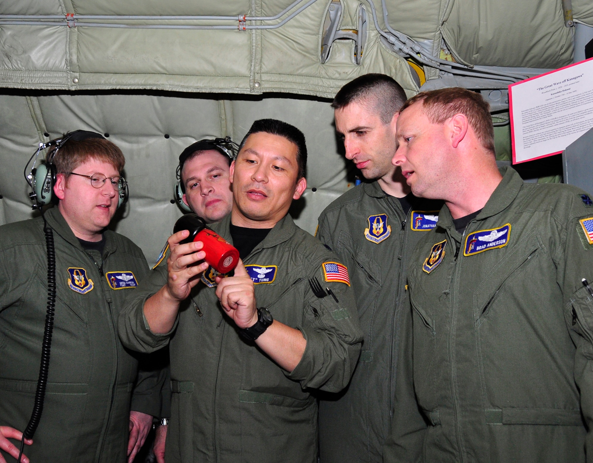 Lt. Col. Tsuyoshi "T" Tung explains the construction of a Japanese hand-made "Kokeshi" doll to fellow crewmembers on board a KC-135 Stratotanker at McConnell Air Force Base, Kan. The crew celebrated Asian-Pacific American Heritage Month during a KC-135 training mission on May 27. Also pictured are KC-135 boom operators Tech. Sgt. Greg Carron and Tech. Sgt Jim Yokom to Colonel Tung's right. To his left are KC-135 pilots Capt. Jon Murphy and Lt. Col. Brad Anderson. They all are Reservists assigned to the 18th Air Refueling Squadron, the flying unit of the 931st Air Refueling Group. (Courtesy photo)