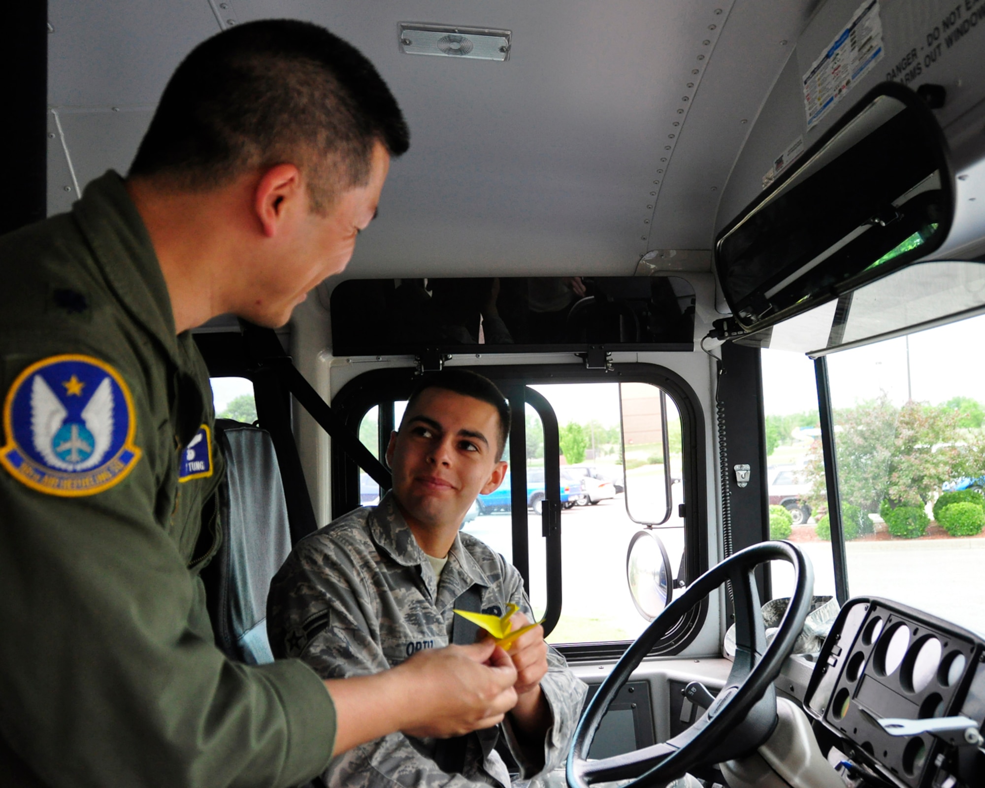 Lt. Col. Tsuyoshi "T" Tung gives an origami crane to Airman 1st Class Johnny Ortiz, an active-duty Airman assigned to the 22nd Logistics Readiness Squadron. Airman Ortiz drove a bus that delivered an 18th Air Refueling Squadron aircrew to a KC-135 Stratotanker at McConnell Air Force Base, Kan., for what Colonel Tung declared as an Asian-Pacific American Heritage Sortie. Giving origami is a custom in Japan, where Colonel Tung was born. He is a KC-135 pilot assigned to the 18th ARS, the Reserve flying unit of the 931st Air Refueling Group. (Courtesy photo/Capt. Jon Murphy)
