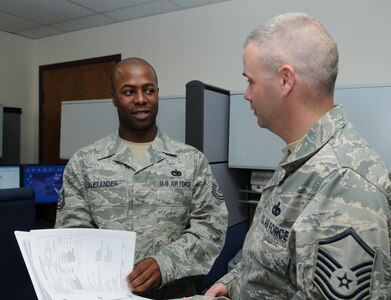 Tech. Sgt. Carl Alexander (left), Air Education and Training Command NCO in charge of vehicle management and analysis, reviews Fiscal 2011 vehicle purchase paperwork with Master Sgt. John Prather on June 12. Sergeant Alexander was recently recognized by Randolph's Chief's Group for his superior service, positive attitude and outstanding demonstration of Air Force core values. (U.S. Air Force photo by Don Lindsey)
