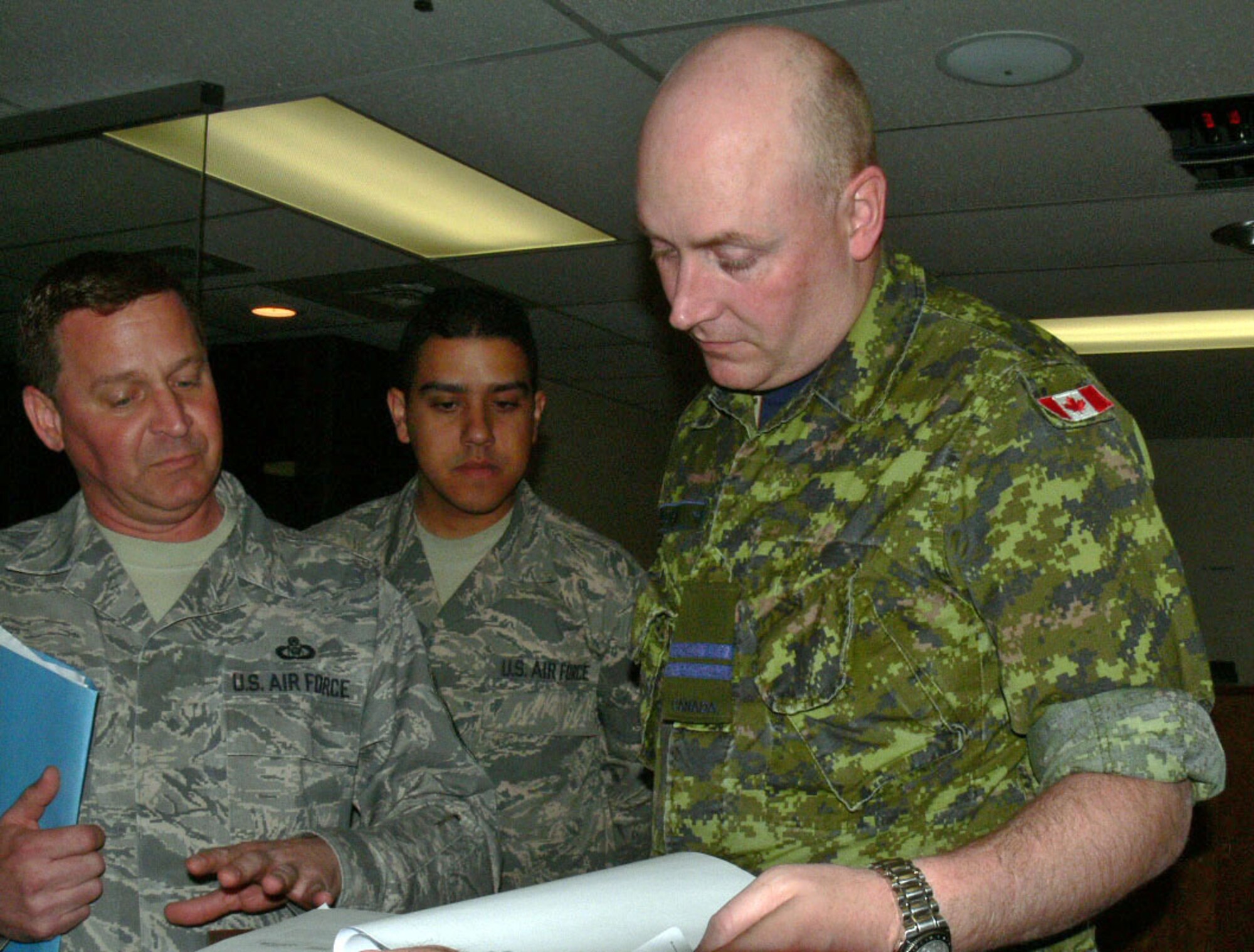 Senior Master Sgt. Paul Veresko from the 439th Air Lift Control Squadron Westover Air Reserve Base, Mass. and Staff Sgt. Johnathan Concepcion of the 512th ALCF Dover Air Force Base, Del. recieve guidance from a captain in the Canadian Air Force prior to conducting an airfield survery. The survey of the airfield at Cold Lake Air Base Alberta Canada will be given to the Canadian Air Force as well as updated in Air Mobility Command's database. Members from the 512th and 439th ALCFs were in Cold Lake supporting Maple Flag Exercise 42. (U.S. Air Force photo/2nd Lt Joe Simms)