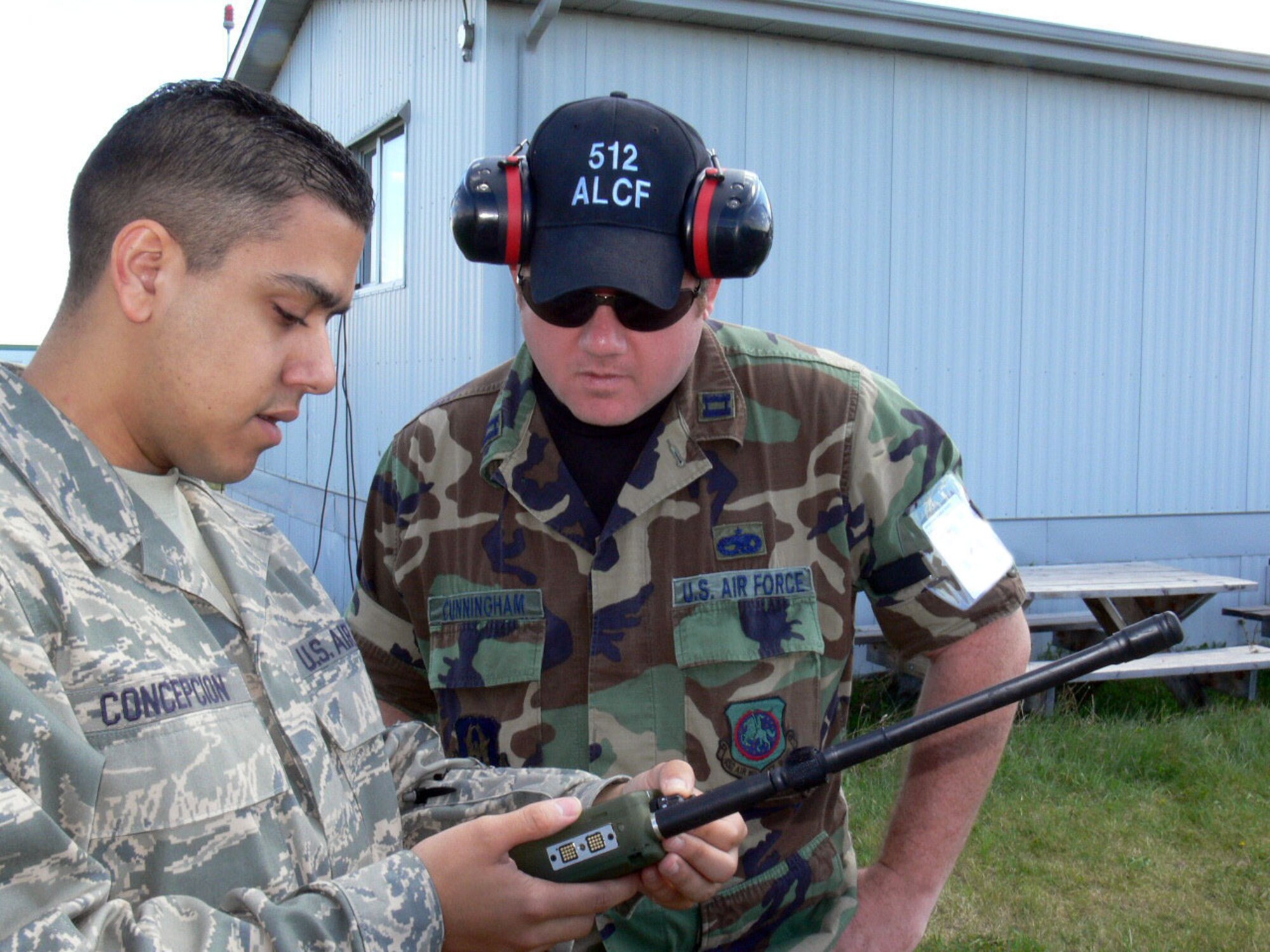 Staff Sgt. Jonathan Concepcion shows Capt. Cliff Cunningham how to program a radio used to monitor several frequencies at once. Both Reservists are from the 512 Airlift Control Flight from Dover AFB Del. The 512 ALCF provided airfield operations for transient aircraft during Maple Flag Exercise 42 at Cold Lake AB Alberta Canada. (U.S. Air Force photo/2nd Lt Joe Simms)