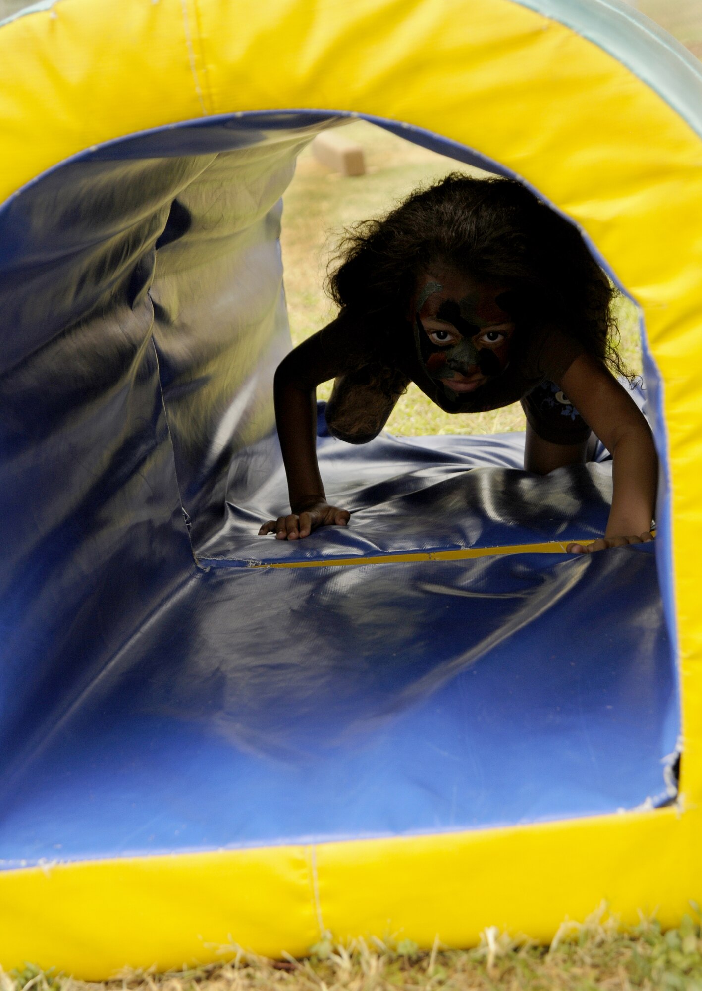 Jayda Hellyer, daughter of Staff Sgt. Kanisha Carson, 39th Medical Operations Squadron, tramples through a tunnel with her warrior paint during the Youth Center kid’s mini-boot camp, Thursday, May 11, 2009 at the softball field at Incirlik Air Base, Turkey. The course was set up for children to gain a little knowledge of what their military parents went through during basic military training and training for deployments. (U.S. Air Force photo/Airman 1st Class Amber Russell)