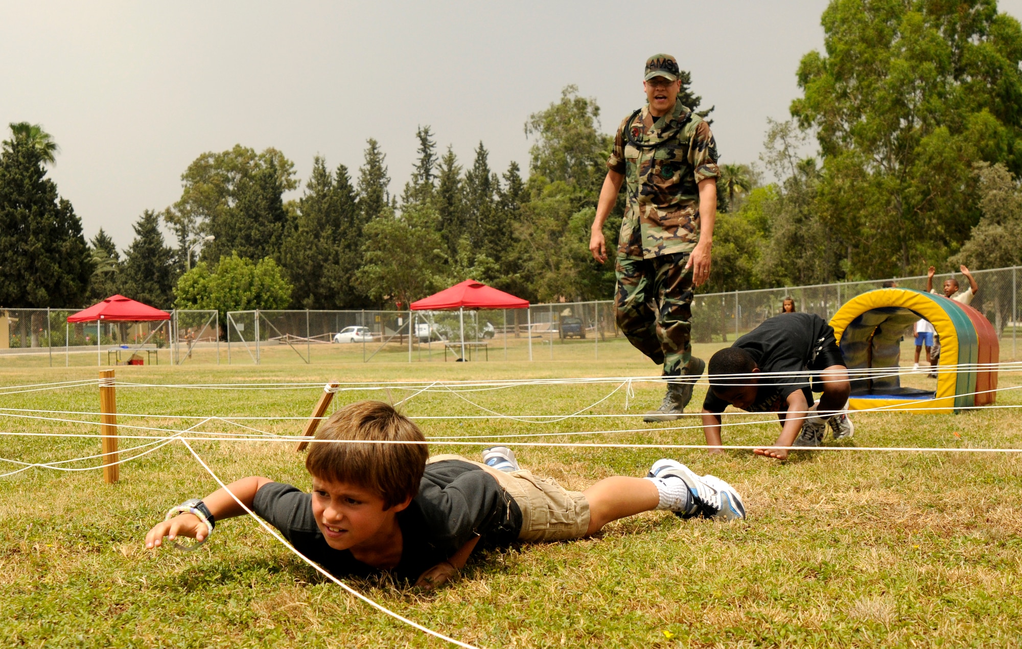 Garrett Steffes, son of Tech. Sgt. Rebecca Huffstotter, 39th Contracting Squadron, crawls under “the wire” during the Youth Center kid’s mini-boot camp, Thursday, May 11, 2009 at the softball field at Incirlik Air Base, Turkey. The course was set up for children to gain a little knowledge of what their military parents went through during basic military training and training for deployments. (U.S. Air Force photo/Airman 1st Class Amber Russell)