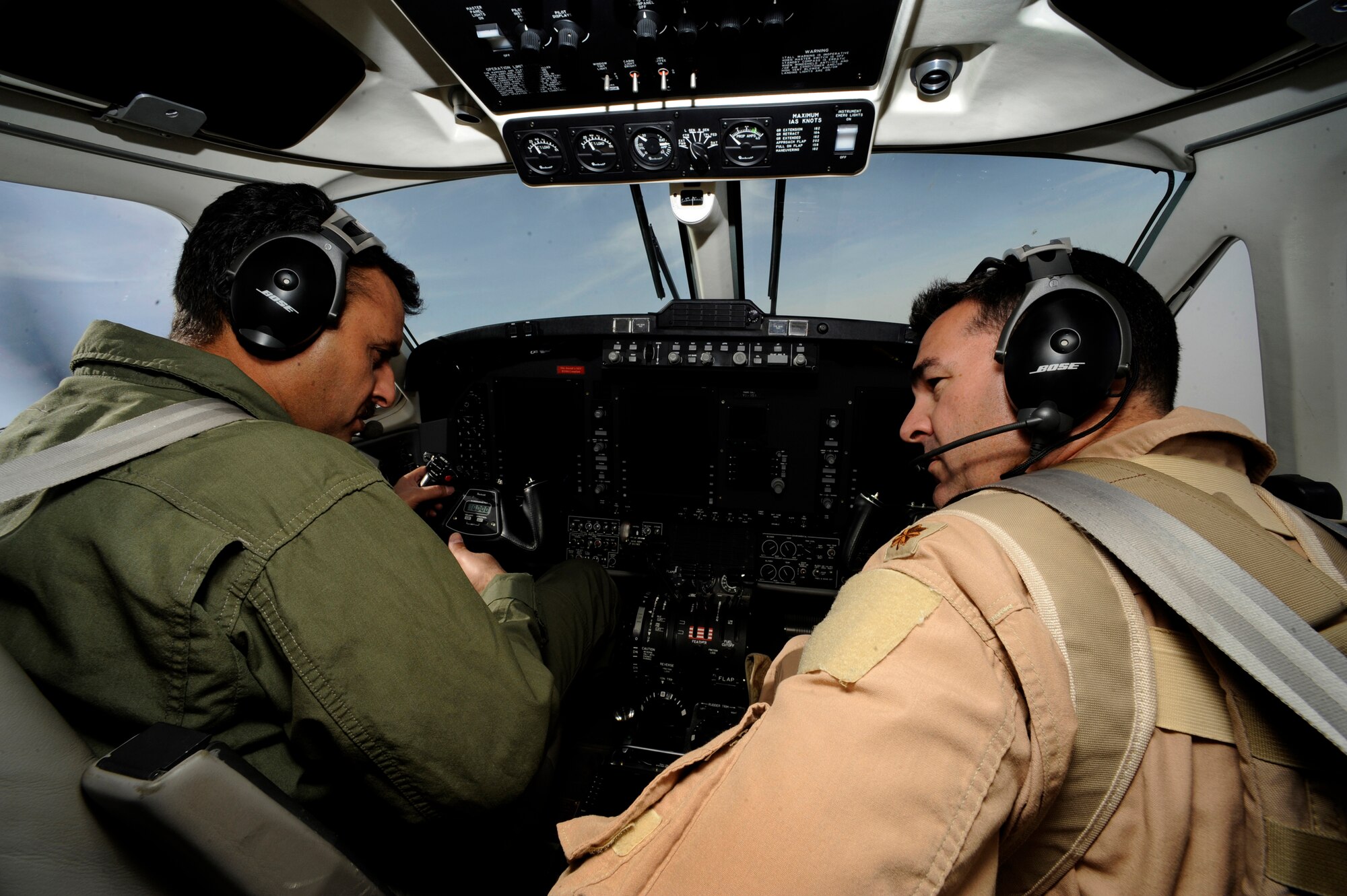U.S. Air Force Maj. Brian Lee, Operations Officer King Air Military Training Team, assigned to the Coalition Air Forces Training Team advises his Iraqi counterpart during an Intelligence, Surveillance and Reconnaissance operations, May 8, 2009, over Iraq. (U.S. Air Force Photo by Staff Sgt. Shawn Weismiller) Weismiller)