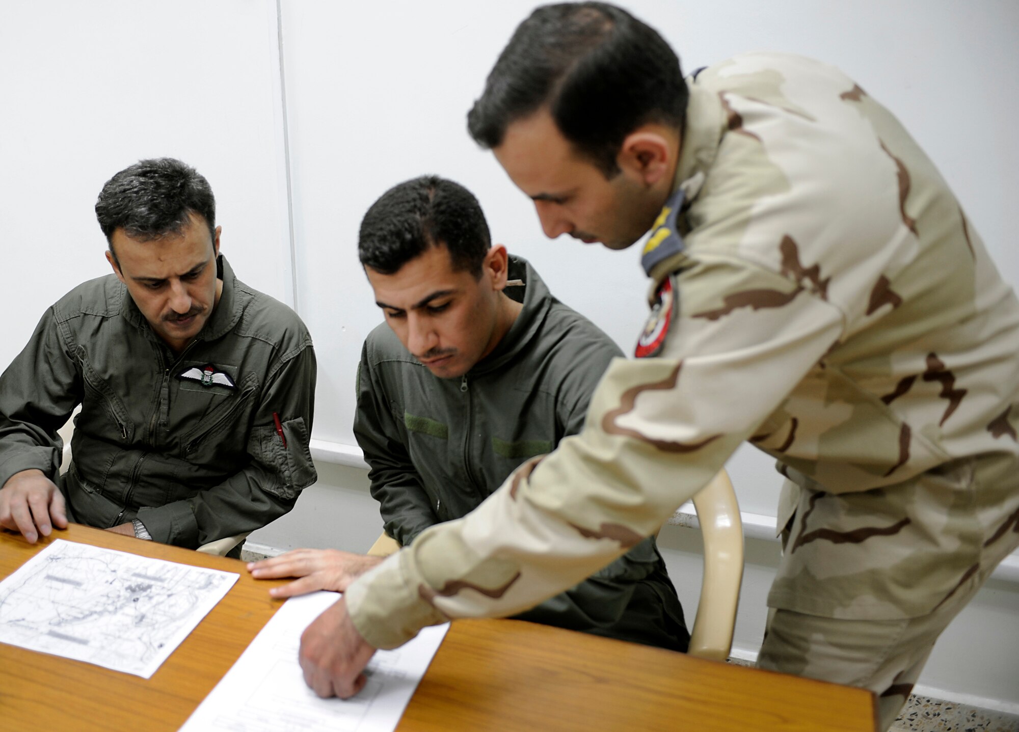 Iraqi Air Force Airmen discuss flight plans prior to departing for a Intelligence, Surveillance and Reconnaissance mission to provide air support of combat operations May 8, 2009, at Al Muthana Air Base, Iraq.  (U.S. Air Force Photo by Staff Sgt. Shawn Weismiller)