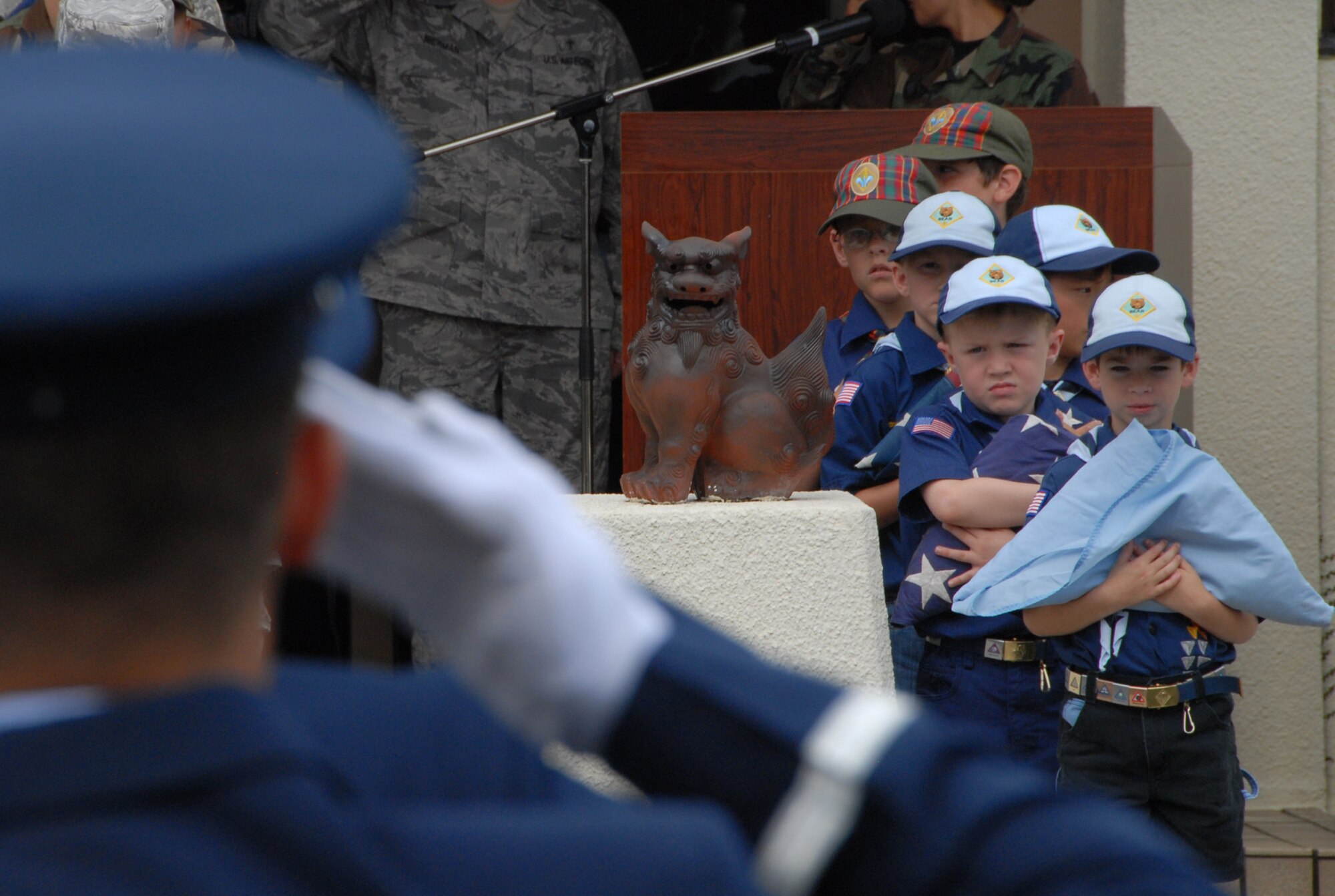 Local Cub Scouts prepare their flags for retirement as a Kadena Honor Guardsman salutes during the 2009 Air Force Sergeants Associations "Flag Day Ceremony", June 12, Kadena AB, Japan. During this ceremony out of service flags were retired by being burned. (U.S. Air Force photo/Staff Sgt. Christopher Hummel)