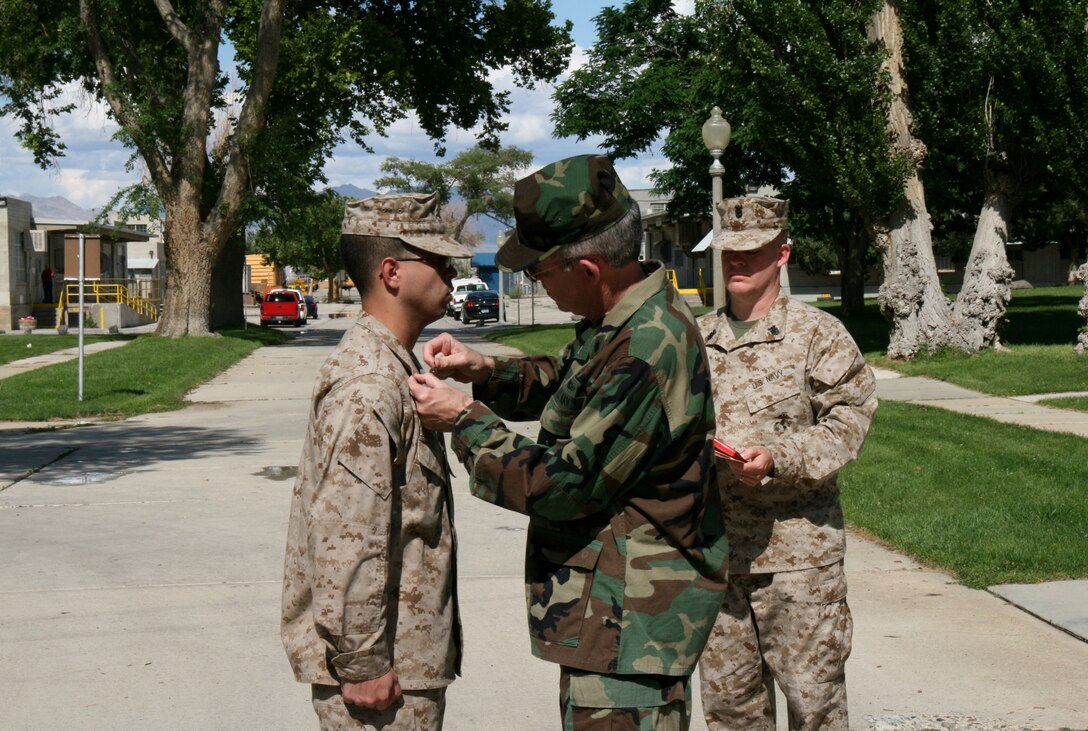 Rear Adm. Bruce A. Doll promotes Private First Class Alfonzo Mantilla to the rank of lance corporal at Hawthorne Army Depot, Nev. June 14.  Doll came to visit the Marines and sailors of Marine Forces Reserve at their summer annual training.  Mantilla, a senior at Oglethorpe University in Atlanta, Ga., is a supply specialist with Headquarters and Service Company, 4th Dental Battalion, 4th Marine Logistics Group, headquartered in Marietta, Ga.