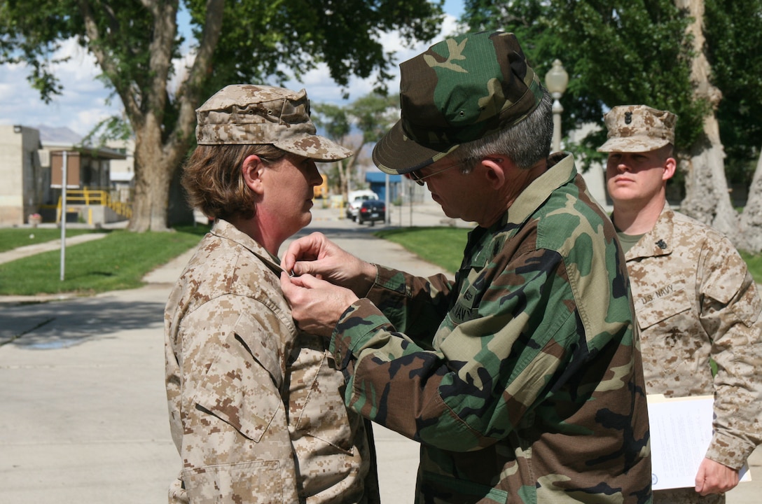 Petty Officer 3rd Class Keli Gallagher, a dental technician with the 24th Dental Company, 4th Dental Battalion, 4th Marine Logistics Group, is frocked to her current rank by Rear Adm. Bruce A. Doll, deputy commander, Navy Medicine East and deputy chief, Navy Dental Corps in a June 14 ceremony at Hawthorne Army Depot, Nev., June 14.  Gallagher, a U.S. Navy Reservist from Eldersburg, Md., is on her two-week annual summer training.  Frocking is a form of early promotion for service members who have been selected for promotion to the next rank and hold a billet which requires the authority of that rank.   Gallagher is a nursing student at Carrol Community College in Westminster, Md.