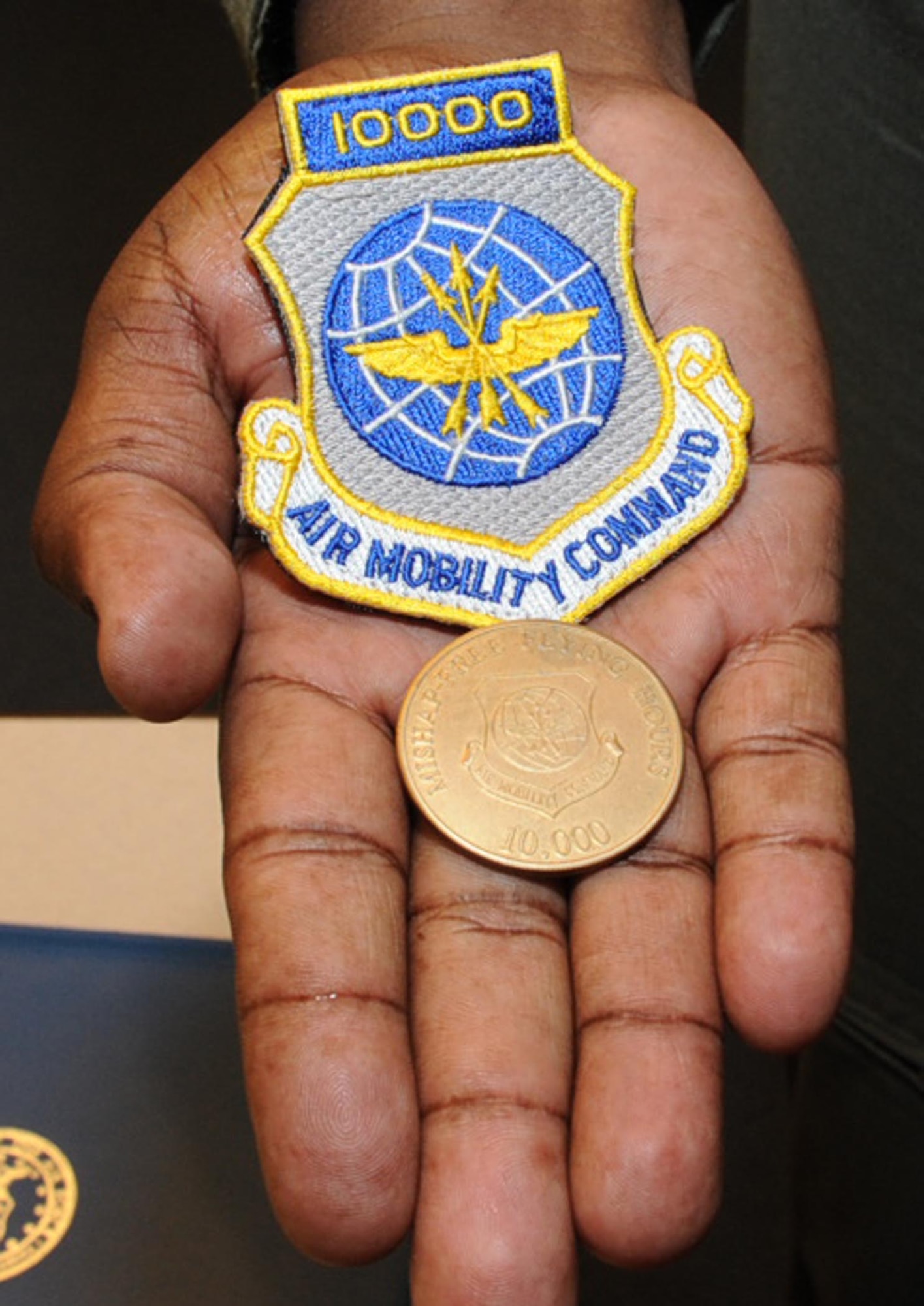 Master Sgt. Terence Jackson of the 32nd Air Refueling Squadron here proudly displays his new patch and coin. Sergeant Jackson was recognized by squadron leadership for achieving a rare milestone in his career: 10,000 mishap-free flight hours. (U.S. Air Force photo/Staff Sgt. Danielle Johnson)