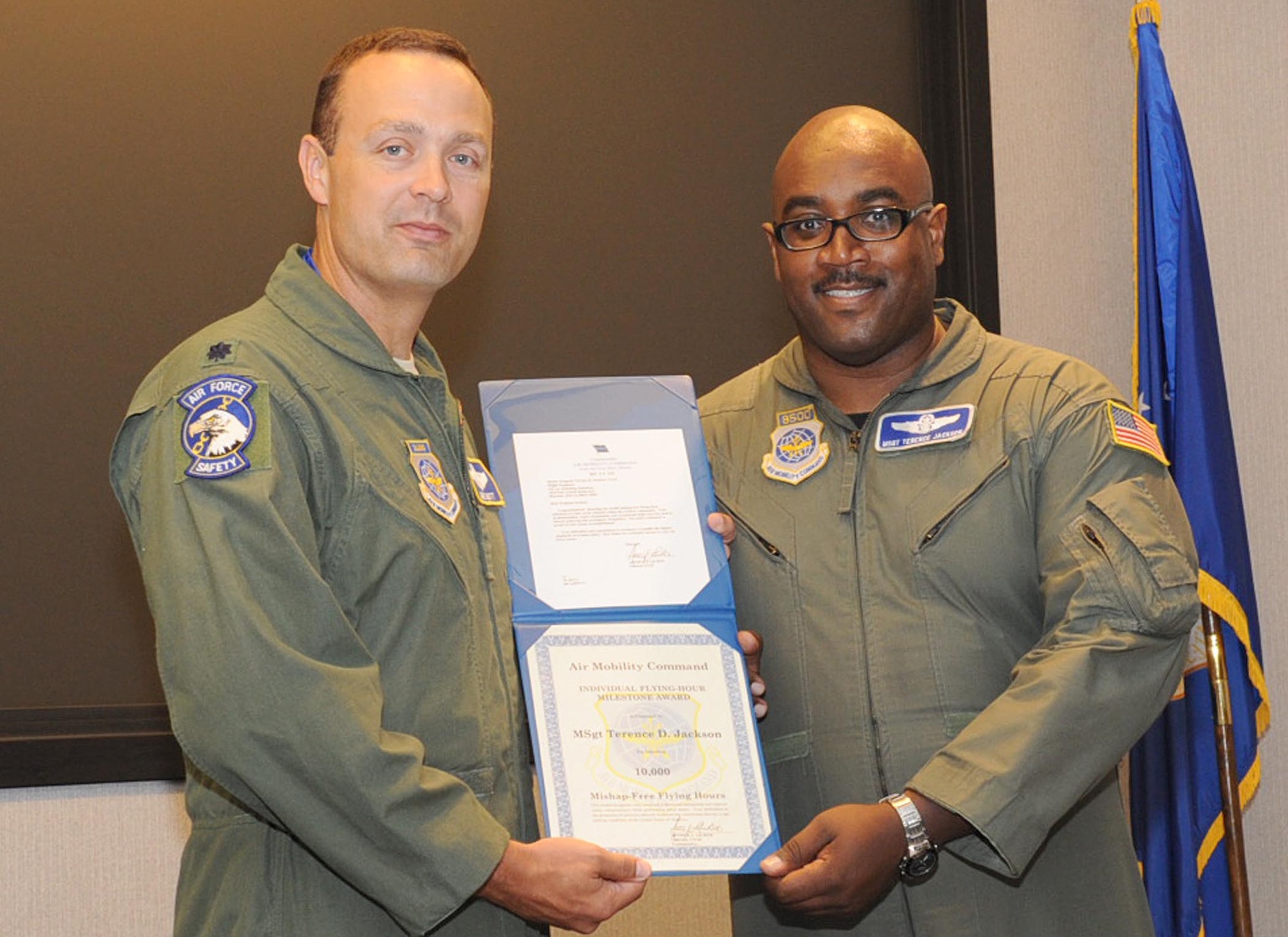 Left, Lt. Col. David Mott, 305th Air Mobility Wing chief of safety, presents a certificate recognizing Master Sgt. Terence Jackson of the 32nd Air Refueling Squadron for achieving a rare milestone in his career: 10,000 flight hours. Colonel Mott emphasized that those flight hours were all mishap-free, a feat that he associates with only a few people who have one characteristic in common: "They love what they do." (U.S. Air Force photo/Staff Sgt. Danielle Johnson) 