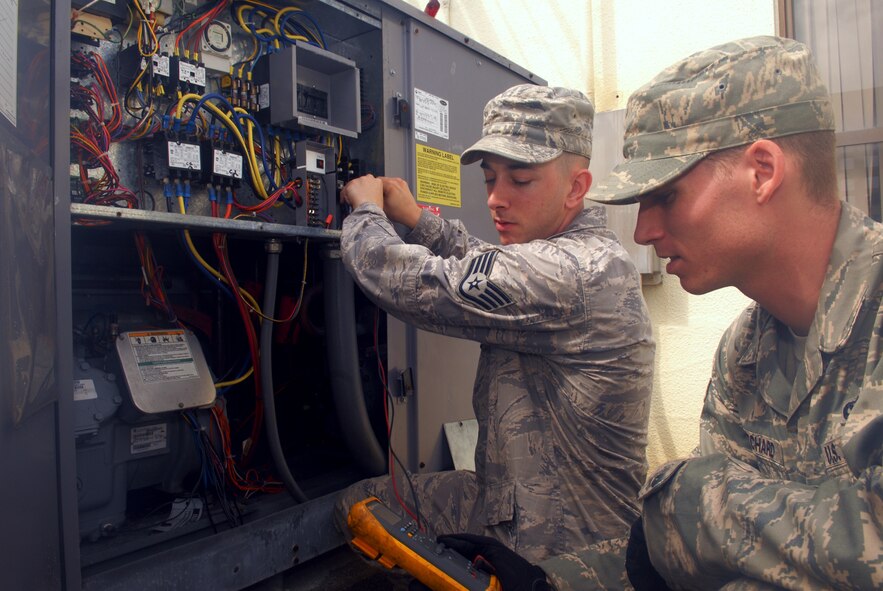 Staff Sgt. Warner Houston and Senior Airman Jace Pritchard, both from the Heating, Ventilation, Air Conditioning, and Refrigeration shop of the 18th Civil Engineer Squadron, check for mechanical and electrical failures in a refrigerator system at Kadena Air Base, June 11. 
(U.S. Air Force Photo/Tech. Sgt. Angelique Perez) 