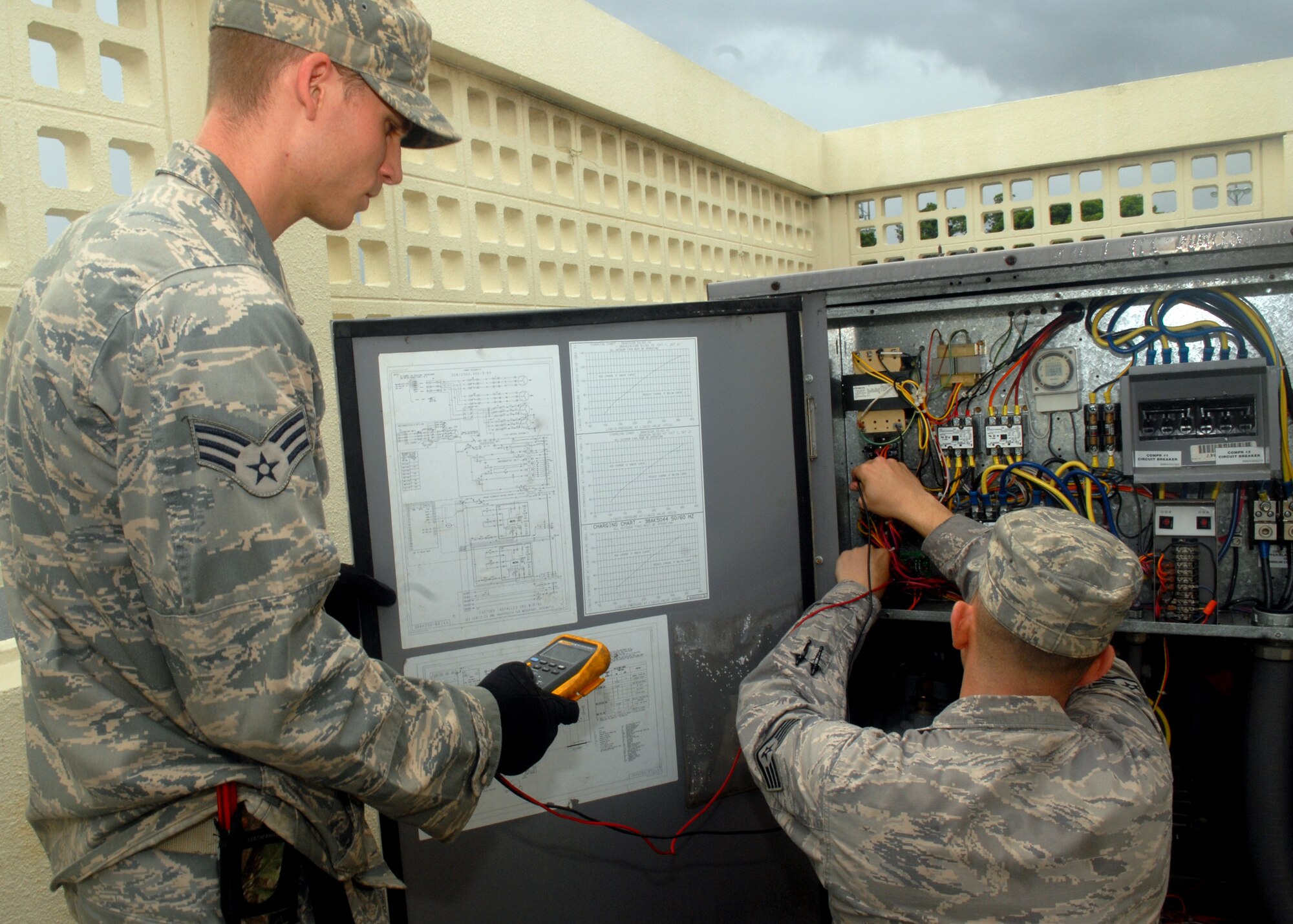 Staff Sgt. Warner Houston and Senior Airman Jace Pritchard, both from the Heating, Ventilation, Air Conditioning, and Refrigeration shop of the 18th Civil Engineer Squadron, check for mechanical and electrical failures in a refrigerator system at Kadena Air Base, June 11. 
(U.S. Air Force Photo/Tech. Sgt. Angelique Perez) 