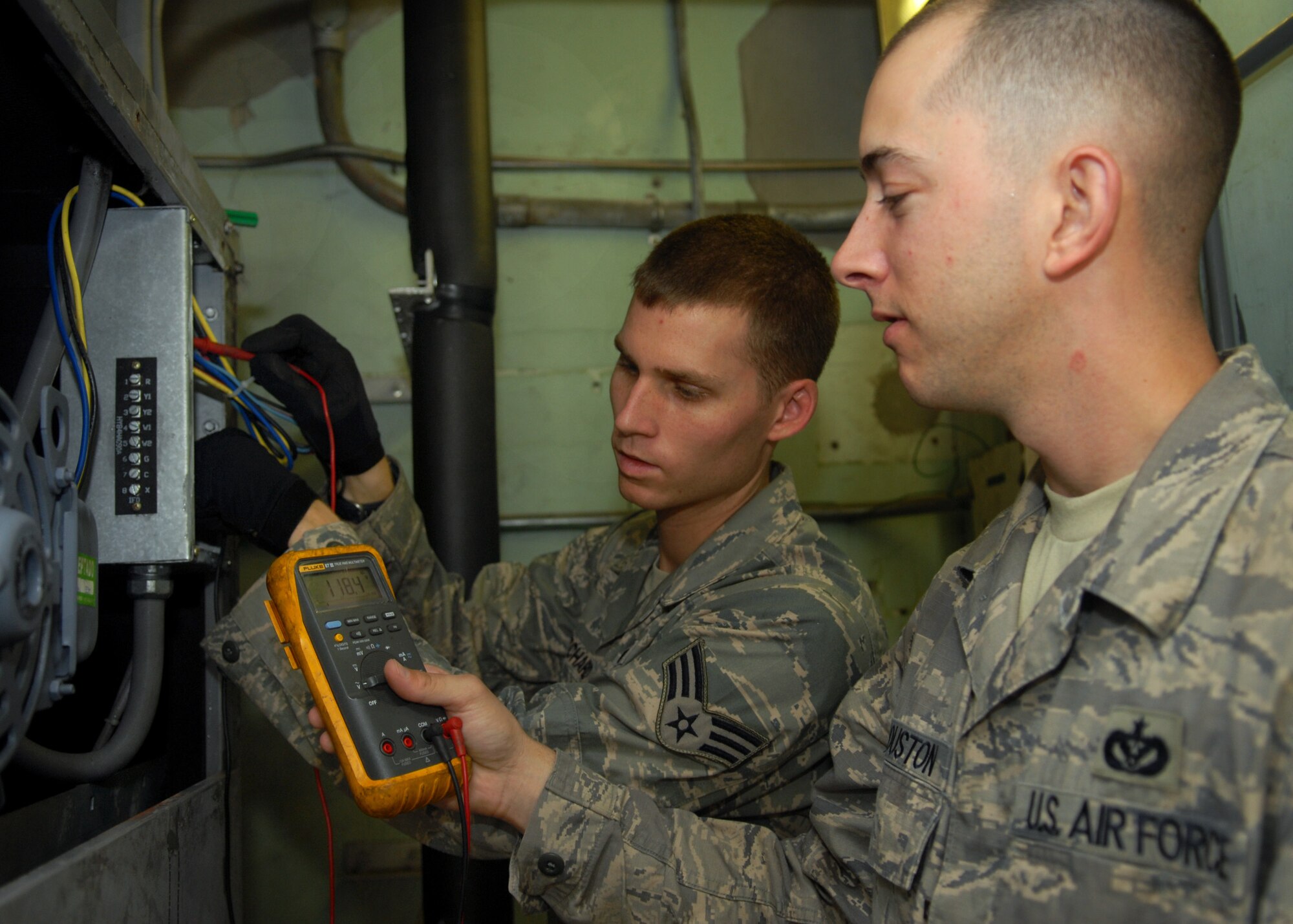 Staff Sgt. Warner Houston and Senior Airman Jace Pritchard, both from the Heating, Ventilation, Air Conditioning, and refrigeration shop, part of the 18th Civil Engineer Squadron, check for malfunctions in a air handler unit at Kadena Air Base, June 11. 
(U.S. Air Force Photo/Tech. Sgt. Angelique Perez) 