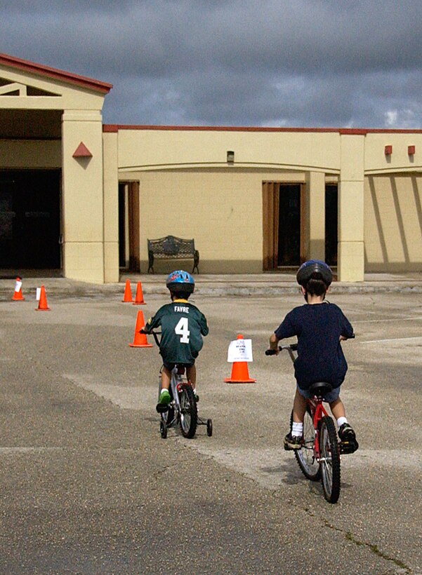 ANDERSEN AIR FORCE BASE, Guam -- (From left to right) Brothers, Drew and Teddy Hicks, sons of Maj. Graham Hicks, 734th Air Mobility Squadron assistant director of operations, maneuvers through a course during the Bicycle Rodeo held at the base pool parking lot June 6. More than 50 Team Andersen dependents participated in this year’s Bicycle Rodeo event, making it a success. (U.S. Air Force photo by Airman Carissa Wolff)