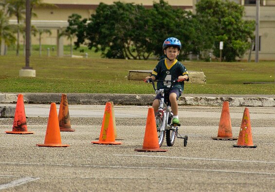 ANDERSEN AIR FORCE BASE, Guam -- Drew Hicks, son of Maj. Graham Hicks, 734th Air Mobility Squadron assistant director of operations, maneuvers his way through a serpentine cone course during the Bicycle Rodeo held at the base pool parking lot June 6. The annual Bicycle Rodeo, a collaborative effort between the 36th Security Forces Squadron and 36th Wing Safety Office, provided a fun, educational event to teach proper safety techniques and proper wear of safety gear while operating several modes of wheeled transportation such as bicycles, skate boards and two-wheeled scooters. (U.S. Air Force photo by Airman Carissa Wolff)        
