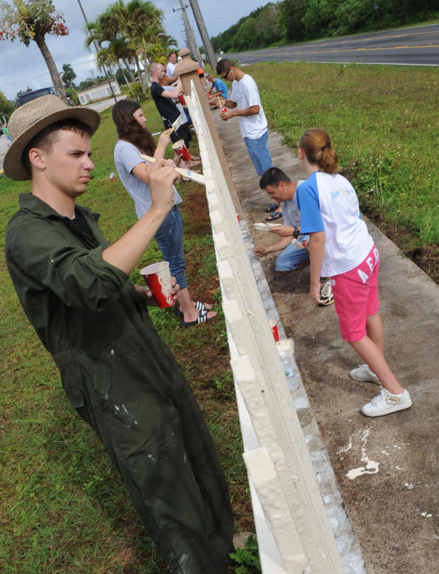 AGANA, Guam – Airmen and Junior Girl Scouts paint a fence at Machananao Elementary School as part of a community service project June 6. More than 100 Airmen from Andersen Air Force Base, Guam, assisted the girls in scrapping rust and painting the fence. (U.S. Air Force photo by Staff Sgt. Jennifer Redente)