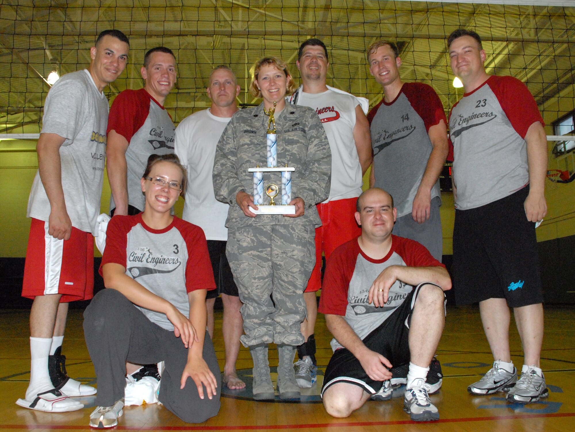 Lt. Col. Sherry Brown, former 436th Civil Engineer Squadron commander, holds the first place trophy after the volleyball championship game at the Fitness Center June 3. The team is pictured: (Back left to right) David Valentin, Allen Middaugh, Mike Doyle, T.J. Gutka, Jeffrey Fowlkes, Joe Voll, (Front left to right) Lori Houck and Daniel Brace. (Air Force photo/ Airman 1st Class Shen-Chia Chu)