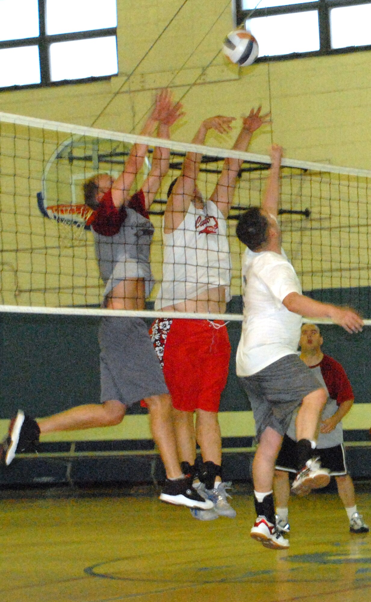 (Right) James Harris, 436th Maintenance Squadron coach, hits the ball with a backwards bump as (Left to right) Jeffrey Fowlkes and T.J. Gutka, 436th Civil Engineer Squadron, come in for a block during the volleyball championship game at the Fitness Center June 3. (Air Force photo/ Airman 1st Class Shen-Chia Chu)