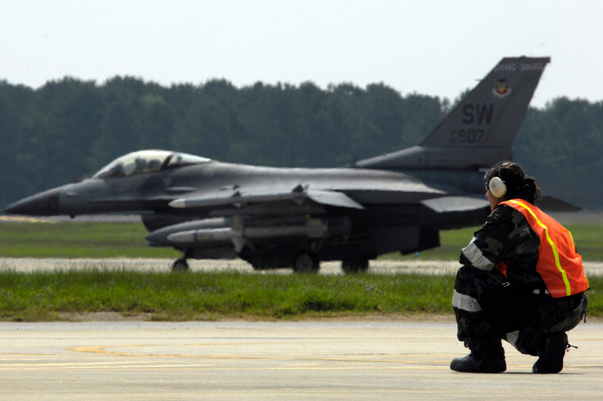 SHAW AIR FORCE BASE, S.C. -- A member of the 20th Aircraft Maintenance Squadron end of runway team watches an F-16 aircraft taxi into position for takeoff during Team Shaw's operational readiness inspection, June 16. The ORI will evaluate Shaw's ability to survive and operate in combat conditions. (U.S. Air Force photo/Senior Airman Kathrine McDowell)