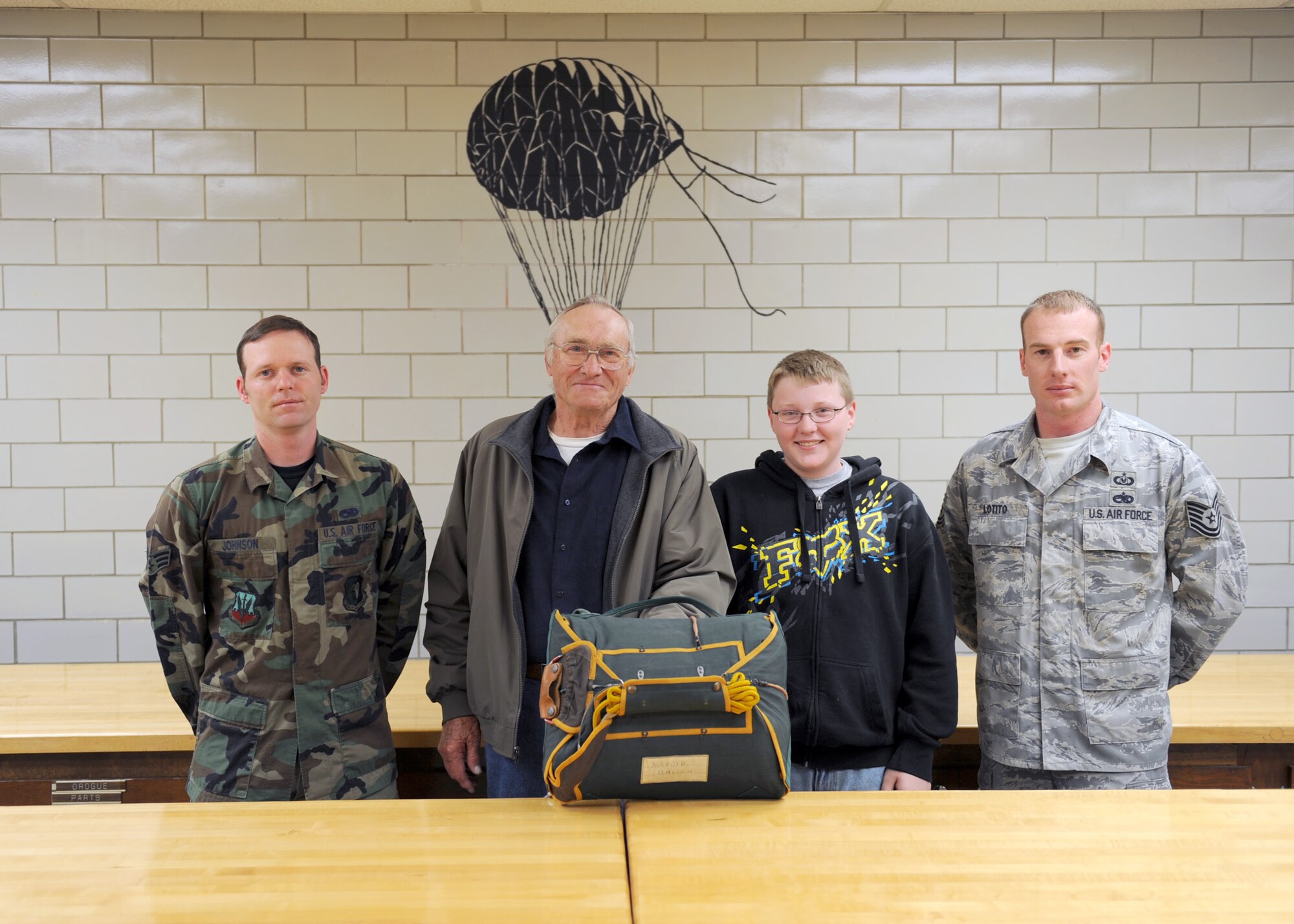 MINOT AIR FORCE BASE, ND -- Tech. Sgt. Dennis Lotito, noncommissioned officer in charge, and Senior Airman Jeremiah Johnson, flight crew equipment journeyman, both from the 5th Operational Support Squadrons Air Flight Crew Equipment office, pose with Mr. Harold Uhlich of Garrison, N.D. and his grandson Christopher Welch of Minot, N.D., here June 11. Mr. Uhlich received the parachute while serving in a security detail in Sasebo, Japan for the U.S. Marine Corps from 1944 to 1946. (US Air Force photo by Staff Sgt. Keith Ballard)
