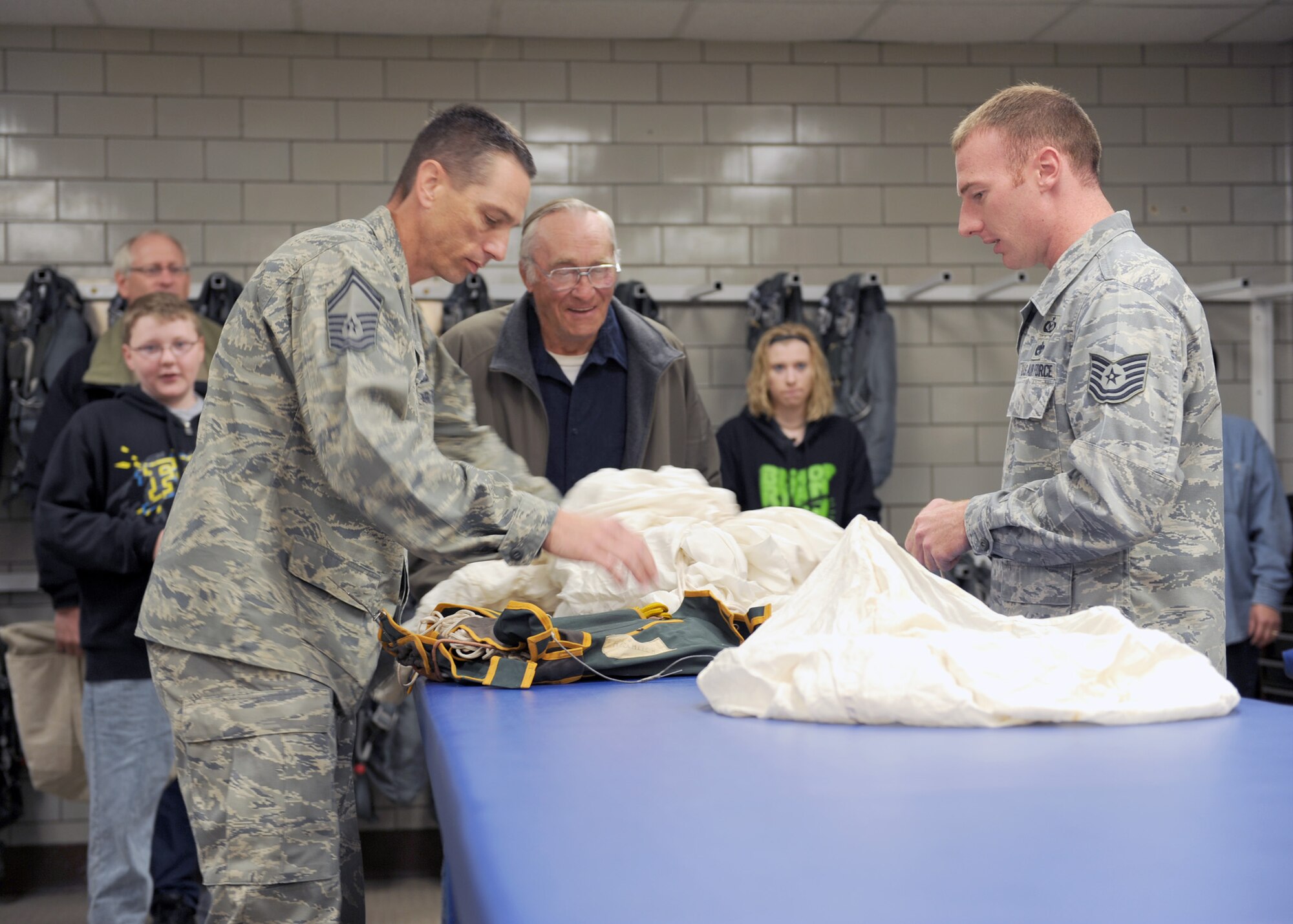 MINOT AIR FORCE BASE, ND -- Senior Master Sgt. Kenneth Boteler, Air Flight Crew Equipment superintendent, and Tech. Sgt. Dennis Lotito, noncommissioned officer in charge, both from the 5th Operational Support Squadron’s Air Flight Crew Equipment office, unpack a Japanese parachute from World War II, here June 11. The parachute is made of heavy silk; the date of manufacture is Nov. 17, 1923. The owner of the parachute, Mr. Harold Uhlich of Garrison, N.D., acquired the piece while serving in a security detail in Sasebo, Japan for the U.S. Marine Corps from 1944 to 1946. (US Air Force photo by Staff Sgt. Keith Ballard)