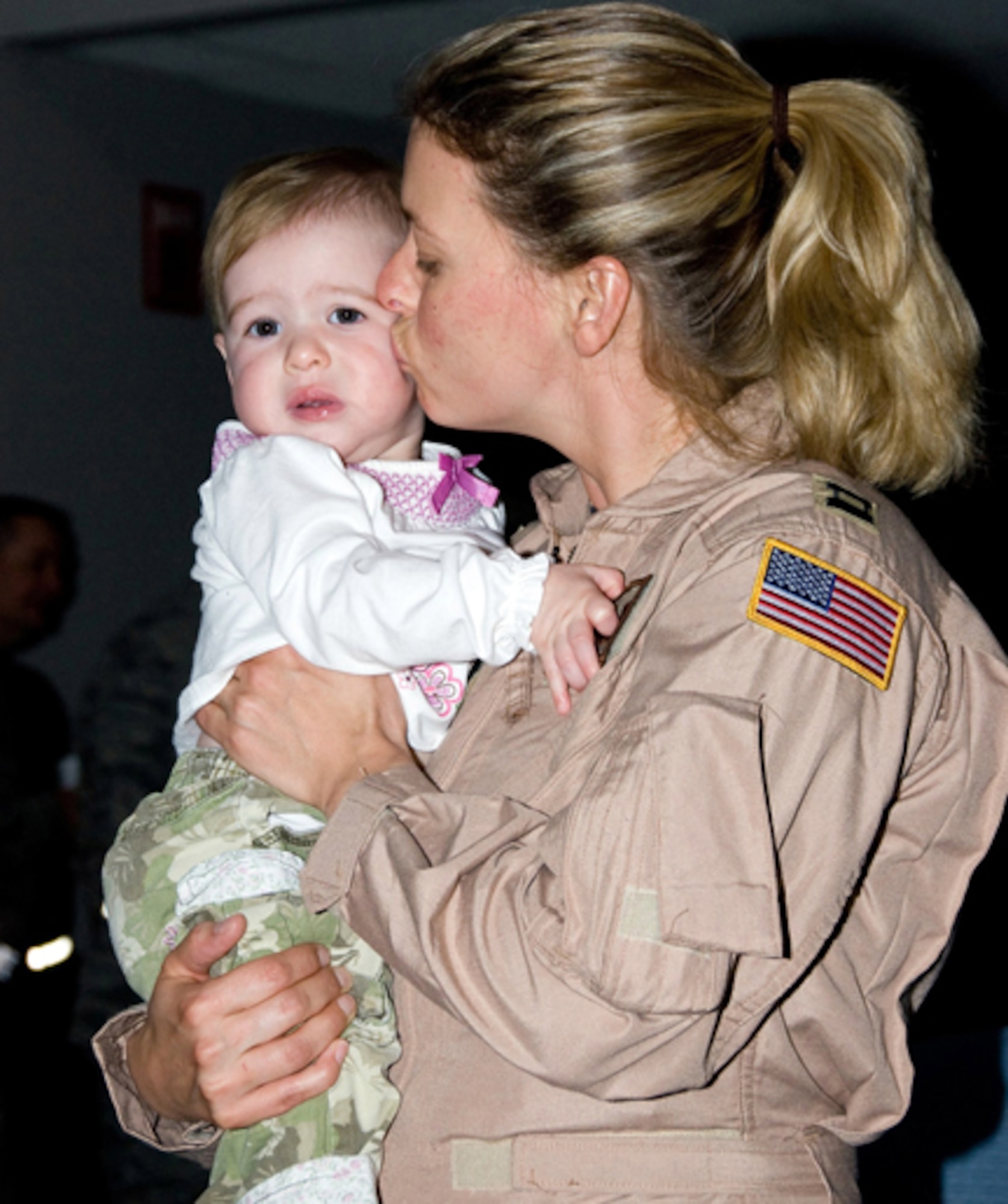 Capt. Becki Restrepo kisses her nine month old baby, Leona Grace, goodbye just before her departure. (U.S. Air Force photo by MSgt Shannon Bond) (RELEASED)