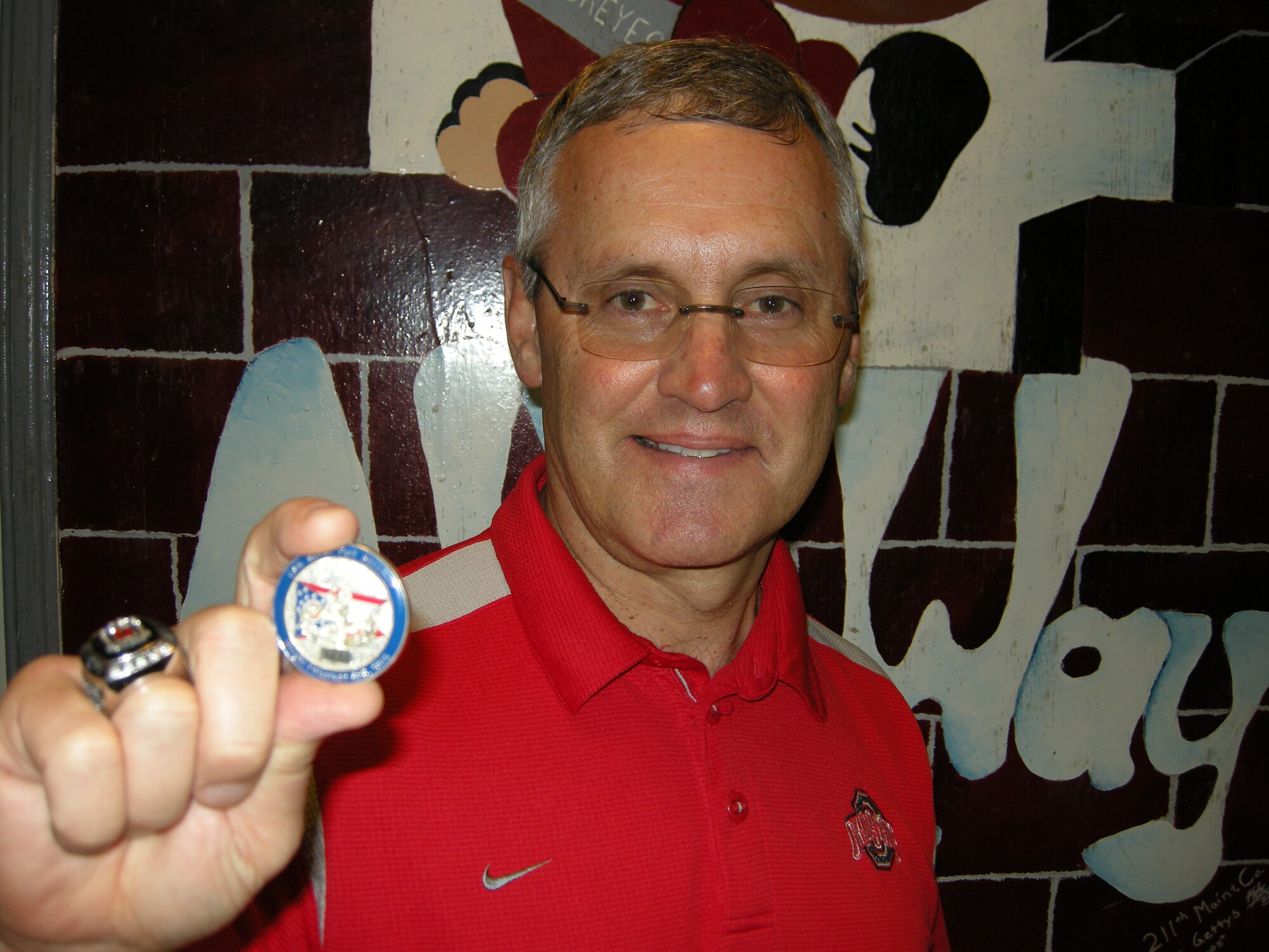 WRIGHT-PATTERSON AIR FORCE BASE, Ohio – 1st Lt. Sean Donelan, 87th Aerial Port Squadron, currently deployed with his unit to Joint Base Balad, presented Ohio State University Coach Jim Tressel an 87th Aerial Port Squadron coin.  Coach Tressel was one of seven NCAA football coaches visiting Joint Base Balad.  The coaches participated in Coaches Tour 2009, a morale-boosting mission that brings NCAA football coaches to U.S. servicemembers currently serving at deployed locations. (Courtesy photo)