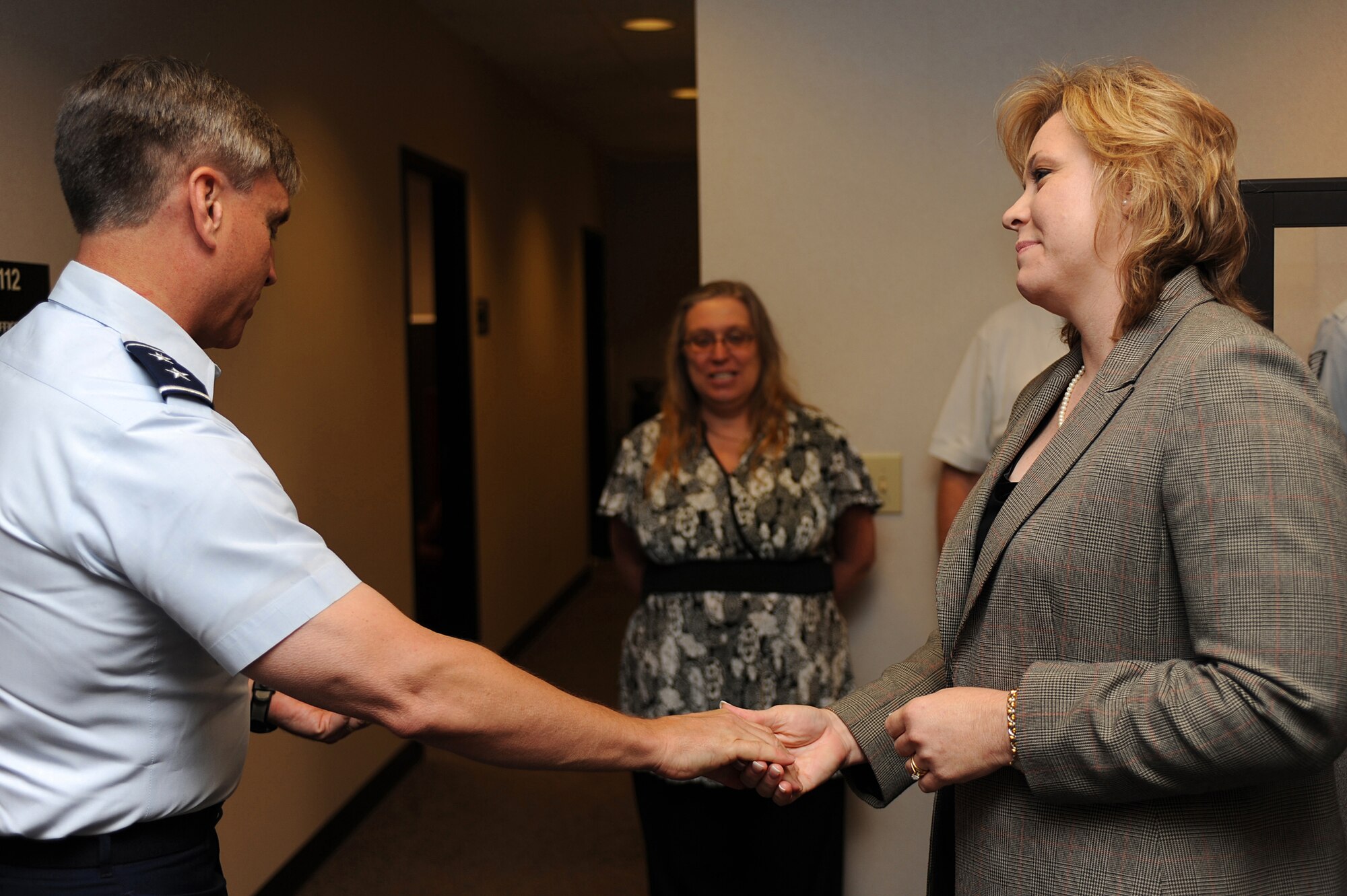 Maj. Gen. Kip Self, U.S. Air Force Expeditionary Center commander, thanks Mrs. Christy Dickinson, financial manager with the Expeditionary Center, by presenting her with a coin June 15 on Joint Base McGuire-Dix-Lakehurst, N.J.  Mrs. Dickinson and Ms. Sandra Lewis, resource advisor with the Expeditionary Center, saved the life of Master Sgt. Dianna Ackerman after an allergic reaction. They are credited with an immediate response in getting Sergeant Ackerman to a medical facility while on temporary duty in Texas. Sergeant Ackerman is now back home and doing well.  (U.S. Air Force Photo/Staff Sgt. Nathan G. Bevier) 