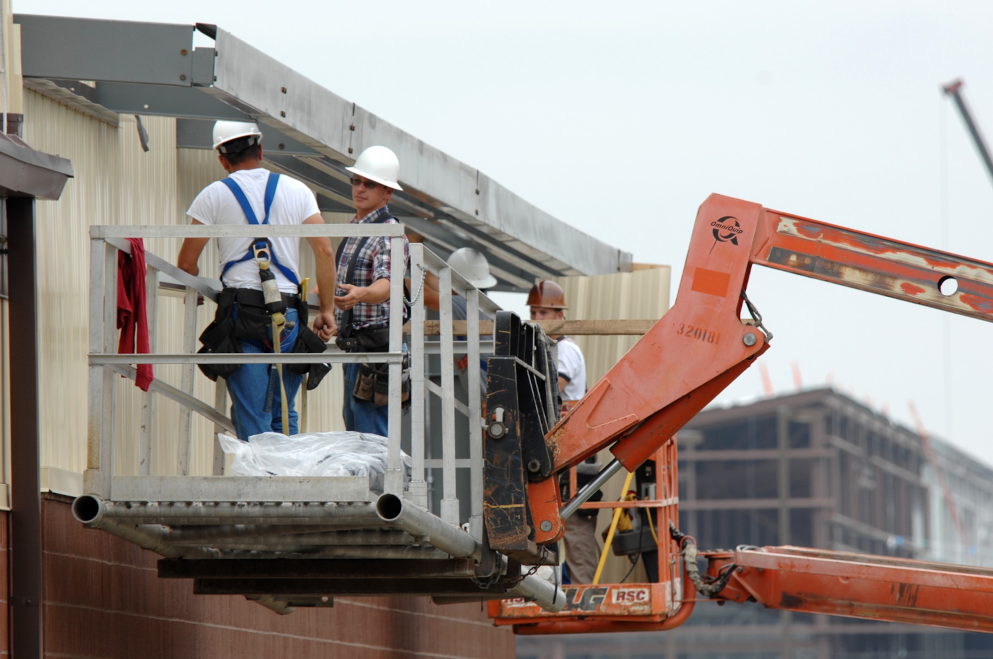 WHITEMAN AIR FORCE BASE, Mo. - Workers from Larry Brandt Construction, attempt to attach sheet metal siding to a new building addition June 10. The workers are constructing an addition to the 442nd Fighter Wing munitions maintenance facility. (U.S. Air Force photo/Tech. Sgt. Charles Larkin)
