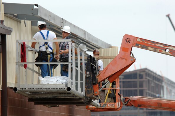 WHITEMAN AIR FORCE BASE, Mo. - Workers from Larry Brandt Construction, attempt to attach sheet metal siding to a new building addition June 10. The workers are constructing an addition to the 442nd Fighter Wing munitions maintenance facility. (U.S. Air Force photo/Tech. Sgt. Charles Larkin)