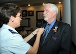 Col. Jacqueline Van Ovost, 12th Flying Training Wing commander, affixes a 50-year service pin to the lapel of Scott Shepherd III, 12th Civil Engineer Division cultural resources manager, during a ceremony June 15. Mr. Shepherd, who was also awarded an Exemplary Civilian Service to the Department of the Air Force medal at the ceremony, retired as a senior master sergeant in 1979 before joining the civil service in 1982. (U.S. Air Force photo by Rich McFadden)