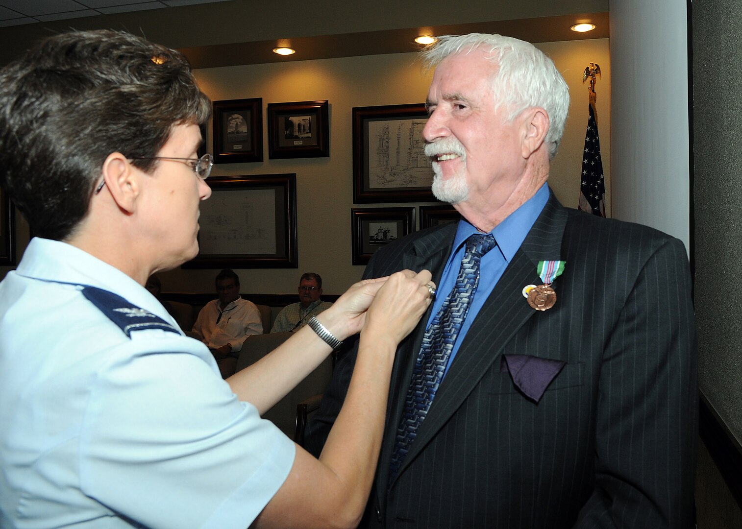 Col. Jacqueline Van Ovost, 12th Flying Training Wing commander, affixes a 50-year service pin to the lapel of Scott Shepherd III, 12th Civil Engineer Division cultural resources manager, during a ceremony June 15. Mr. Shepherd, who was also awarded an Exemplary Civilian Service to the Department of the Air Force medal at the ceremony, retired as a senior master sergeant in 1979 before joining the civil service in 1982. (U.S. Air Force photo by Rich McFadden)