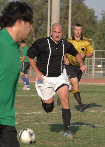Master Sgt. Corey Bowen, 39th Operations Squadron, dribbles the ball down the field during the base intramural soccer finals, Monday, June 15, 2009, Incirlik Air Base, Turkey. The game ended in a shootout between the two teams, with the CES scoring 3-of- 4 kicks to the OS 2-of- 5 kicks. The finals consist of a double elimination tournament, therefore, the two squadrons will play again Tuesday, June 16, 2009 to determine the winner. (U.S. Air Force photo/Staff Sgt. Lauren Padden). 