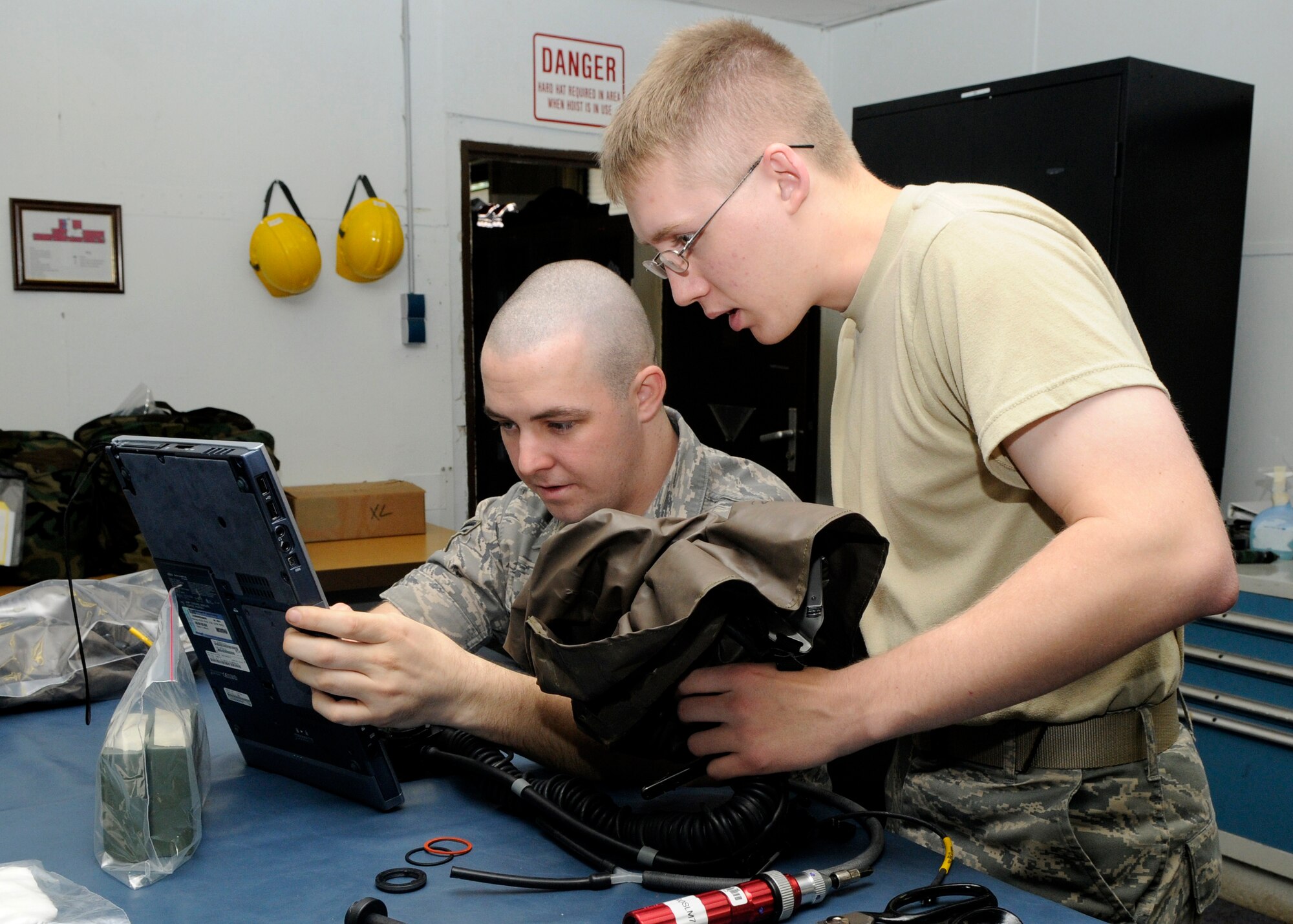 SPANGDAHLEM AIR BASE, Germany – Airman 1st Class Anthony Pulcini and Airman 1st Class Anthony Farnsworth, 52nd Operations Support Squadron aircrew flight equipment technicians, retrieve digital technical orders needed to begin testing life support equipment June 12. Aircrew flight equipment technicians repair and inspect nearly everything a pilot wears and takes into the cockpit.  (U.S. Air Force photo by Airman 1st Class Staci Miller)