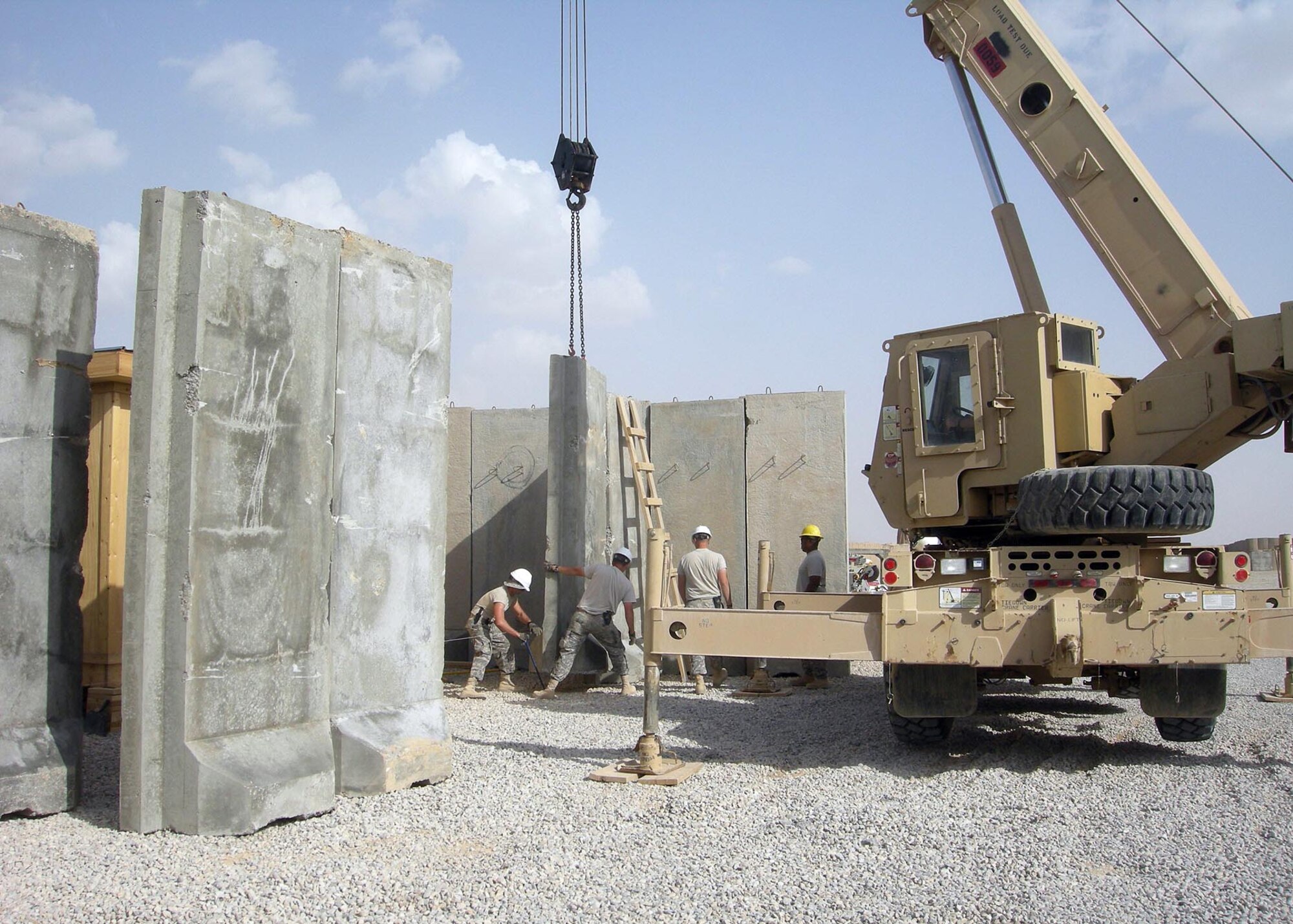 Airmen from the 732nd Expeditionary Civil Engineer Squadron Detachment 3, place Texas-style barriers around Patrol Base Shocker, Iraq in April 2009.  The Airmen placed 60 barriers to increase force protection measures for over 15 living tents, hygiene facilities, and a Quick Reaction Force motor pool. The Airmen were part of a construction team sent to support the vertical construction phase to bed-down over 140 additional Soldiers to be assigned to the base. The team of Airmen are from Patrick Air Force Base, Fla.  (Courtesy Photo)