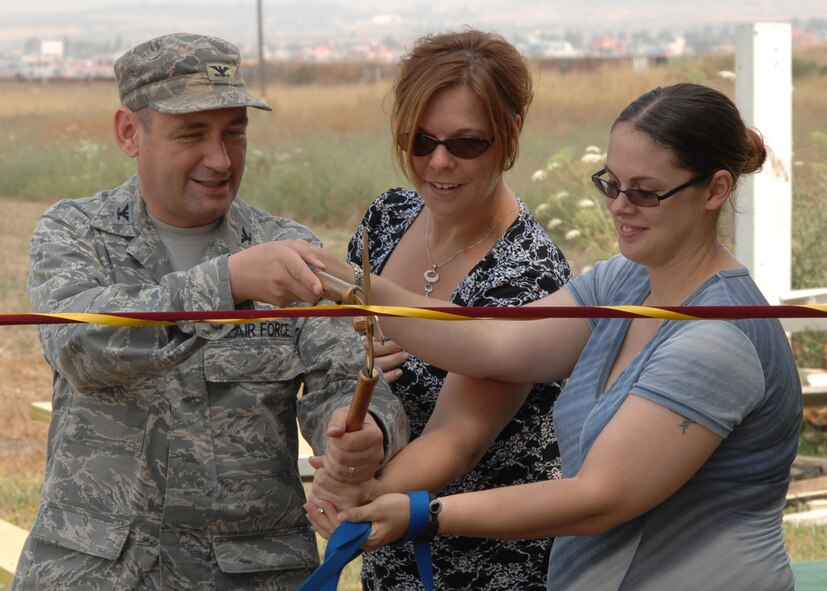 Col. Andrew Pears, the 39th Mission Support Group commander, Deanne Acree and Staff Sgt. Lisa Pope, Dog Patch volunteers, cut the ribbon on opening day of the Dog Patch dog park, Saturday, June 13, 2009, Incirlik Air Base, Turkey. Dog Patch is a private organization run by volunteers to offer a space for all dogs on base to run free in a confined area. The volunteers organized fundraisers, collected donations of materials and worked numerous weekends to make the park people and dog friendly. Park hours are from sunrise to sunset and require all dogs to be supervised by the owner and fully vaccinated. (U.S. Air Force photo/Staff Sgt. Lauren Padden)
