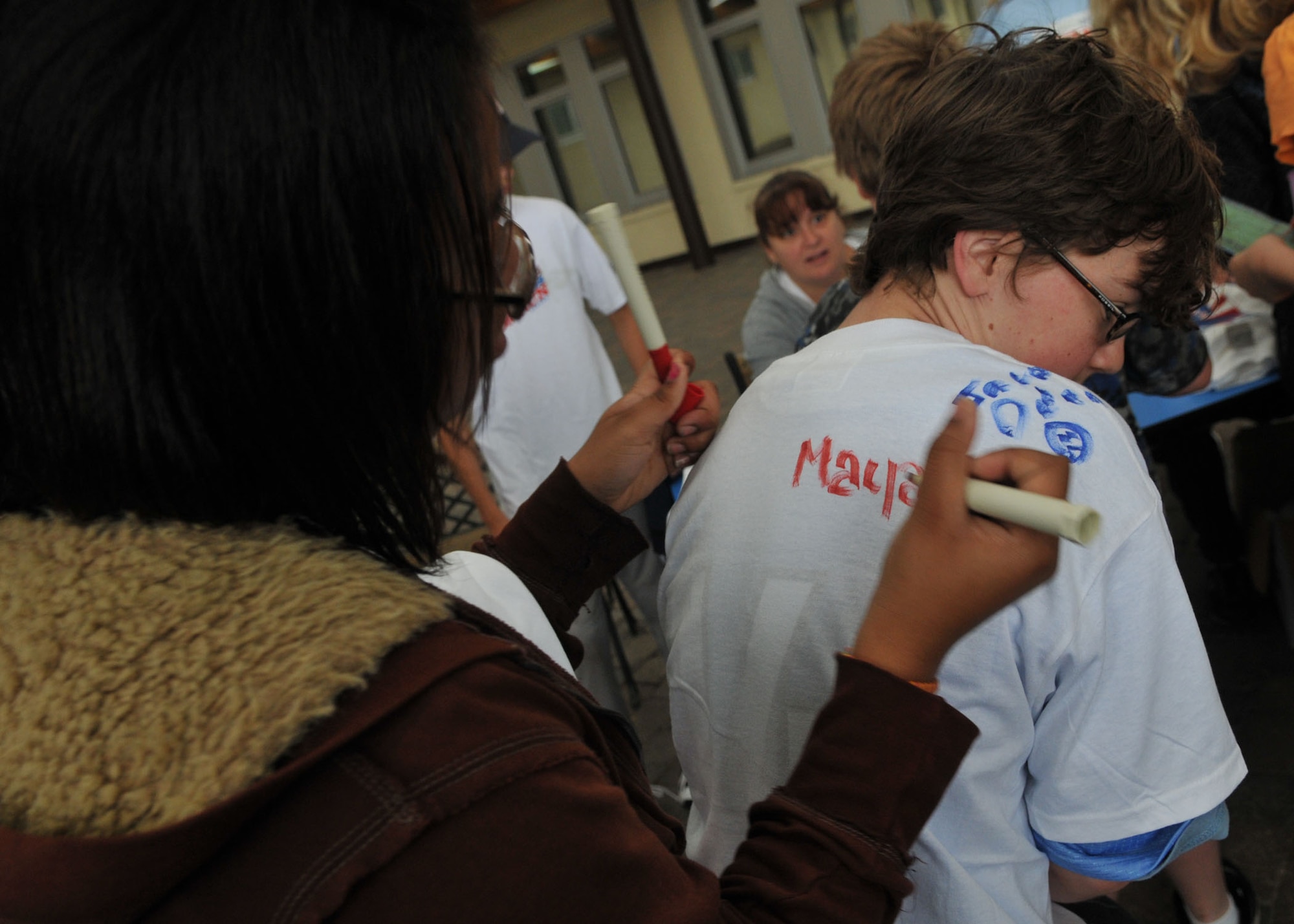SPANGDAHLEM AIR BASE, Germany – Mya Sanders signs the T-shirt of VanAckern Taylor after the “Race into Summer” at Bitburg Middle School June 11. Each student had the opportunity to sign their friends’ T-shirts after the race. (U.S. Air force photo by Airman 1st Class Nick Wilson)